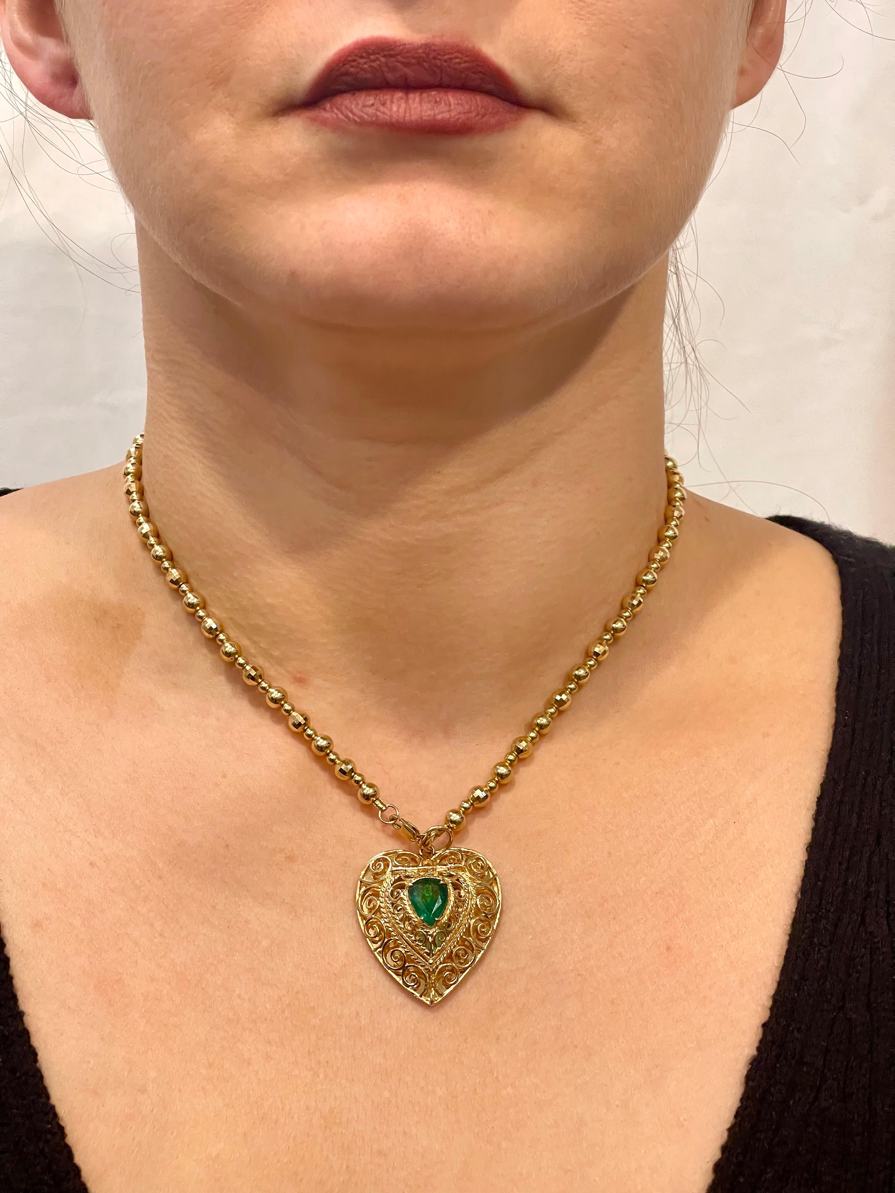 Vintage 14 Karat Yellow Gold  Heart Locket and Natural Emerald
Heart Locket is 12 inch wide and 1.3 Inch long 
CHAIN IS NOT AVAILABLE 
Natural Brazilian Emerald , Pear shape , approximately 2.5 ct
Locket open where you can save medicine or