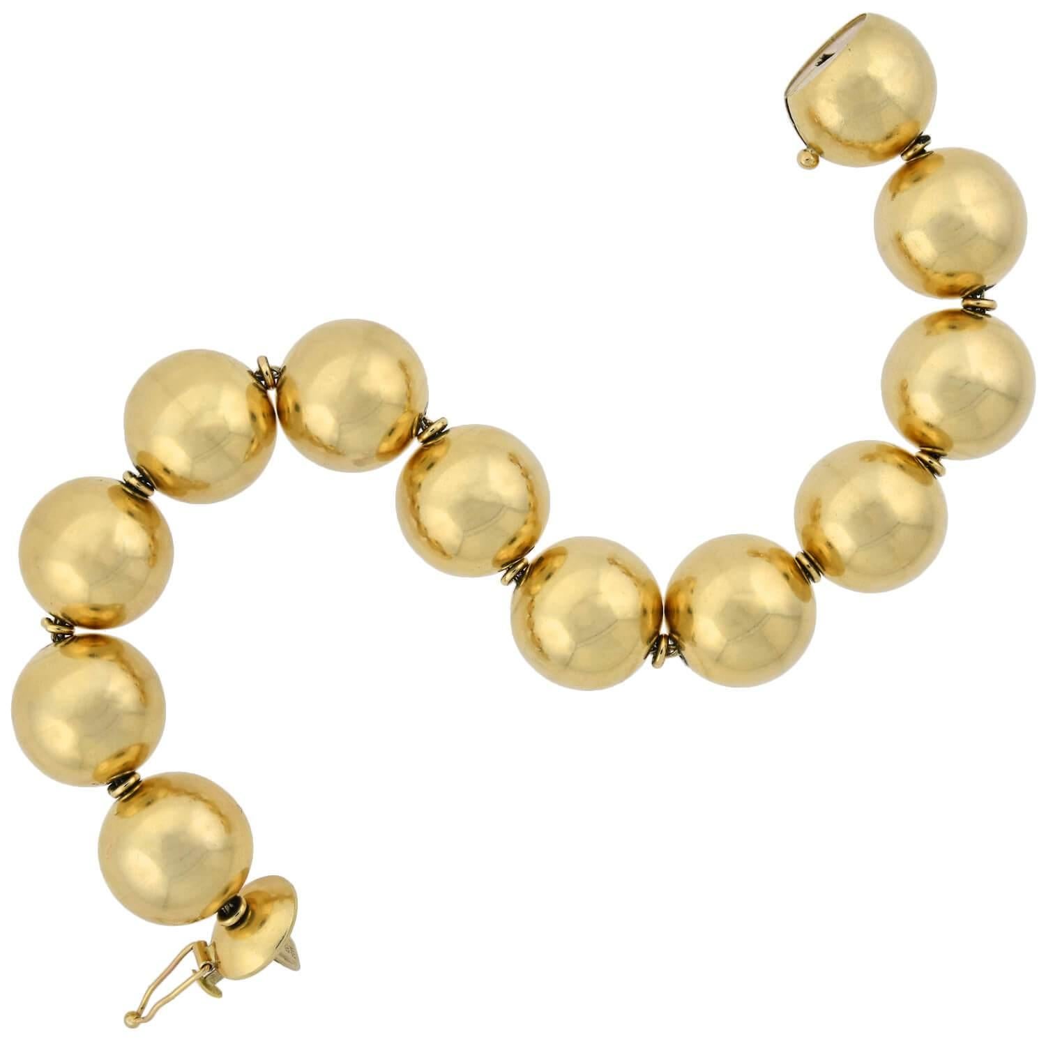 Un superbe bracelet vintage en perles d'or des années 1950 ! Réalisé en or jaune 14 carats, ce bracelet simple mais accrocheur est composé de 12 boules d'or poli uniment, qui forment un motif droit mais flexible qui s'enroule autour du poignet. Les