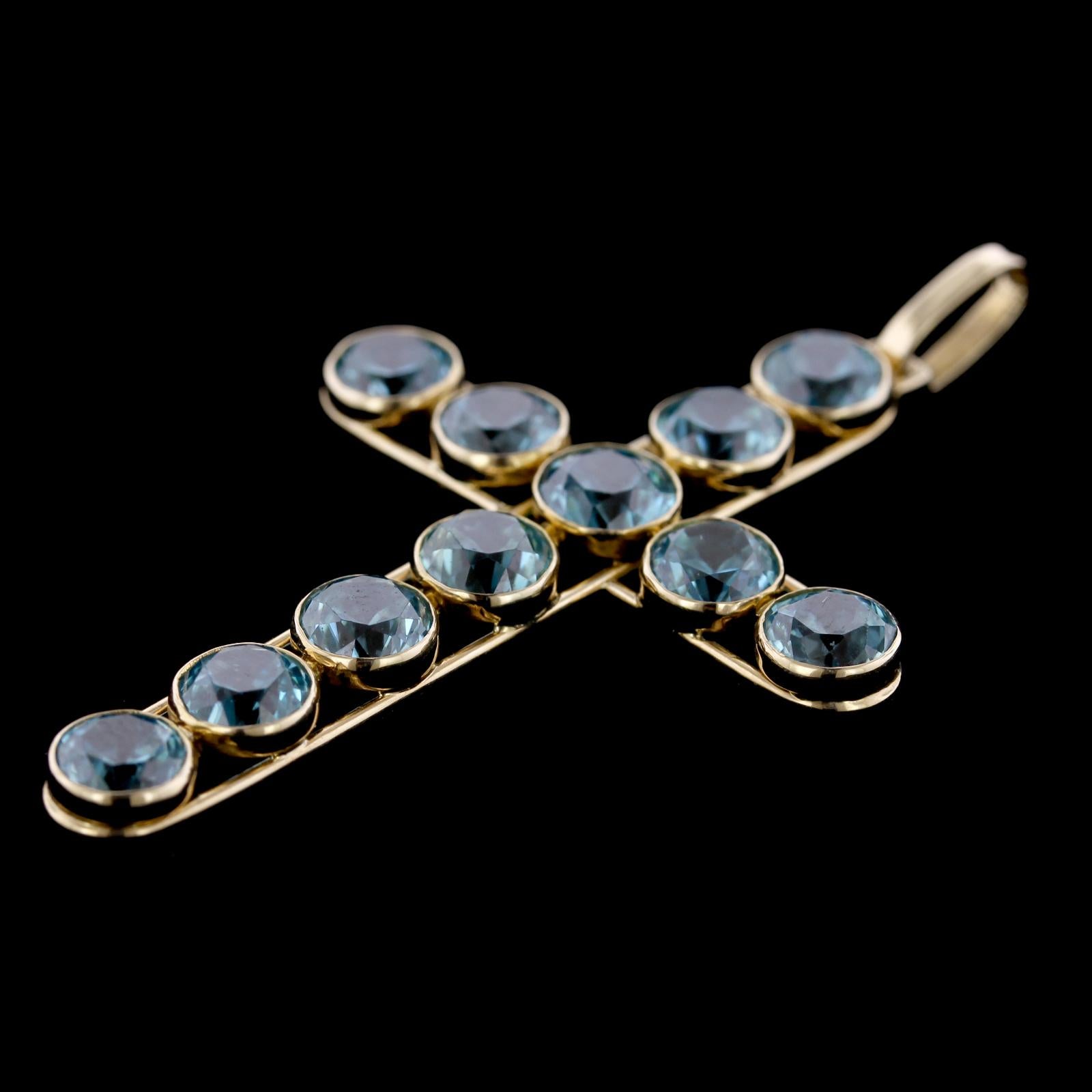 Vintage 14K Yellow Gold Blue Zircon Cross. The pendant is bezel set with 11 blue zircons each measuring 5.00mm., length 2