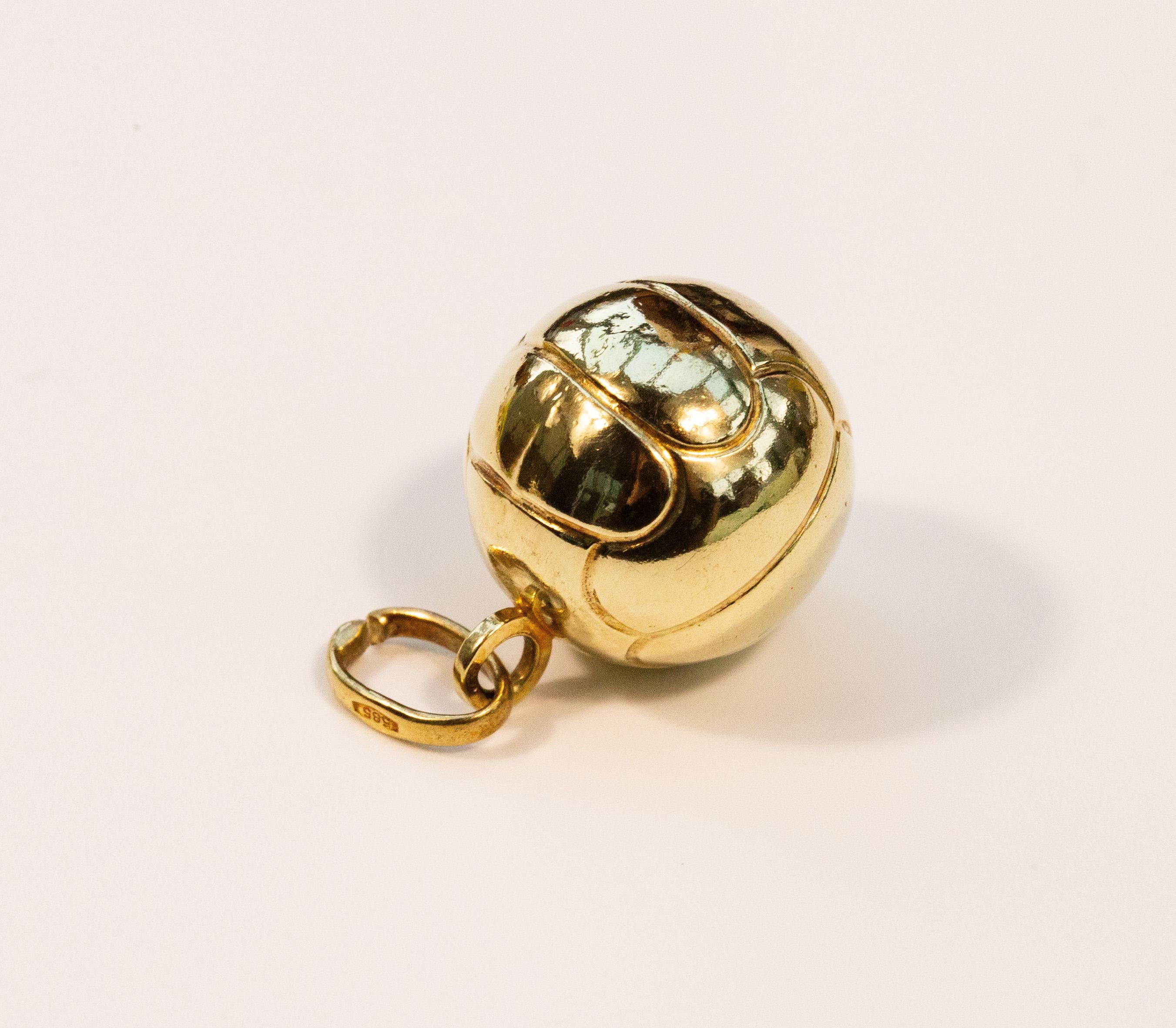 A vintage football charm made of 14 karat yellow gold. The charm features a textured surface that resembles the surface of a football. The item was manufactured at the late 20th century. It is in good vintage condition with normal to its age patina.