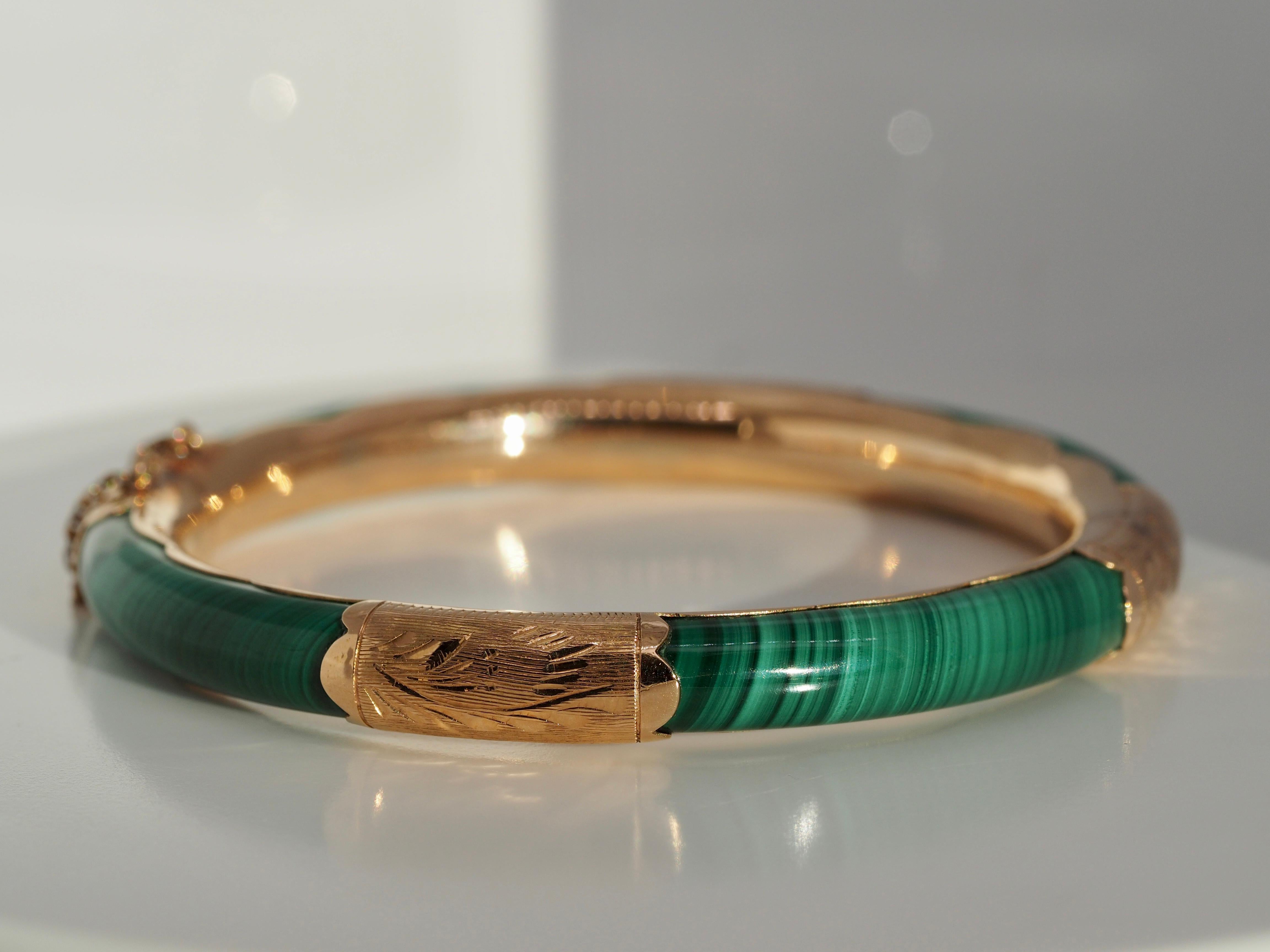 Vintage 14 karat yellow gold green Malachite hinged cuff bracelet. This bracelet has a beautiful green Ombre design to the jade, with safety features including a clasp that latches shut with a chain connecting both ends of the bracelet. It is in