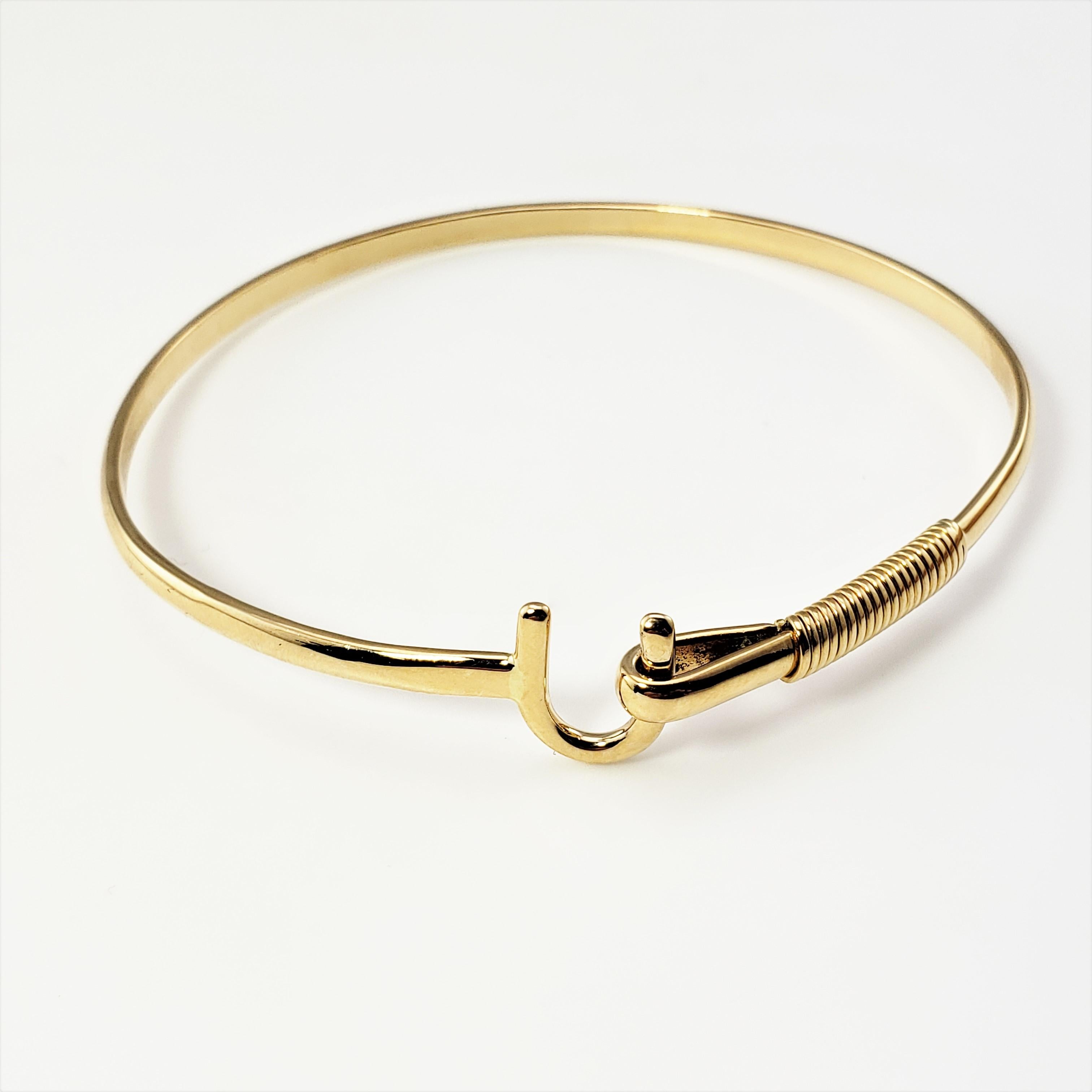 Vintage 14 Karat Yellow Gold St. John's Hook Bangle Bracelet-

This elegant bracelet feature a front hook closure crafted in beautifully detailed 14K yellow gold. Width: 11 mm.

If the hook is worn inwards, it means your heart is caught. If you are