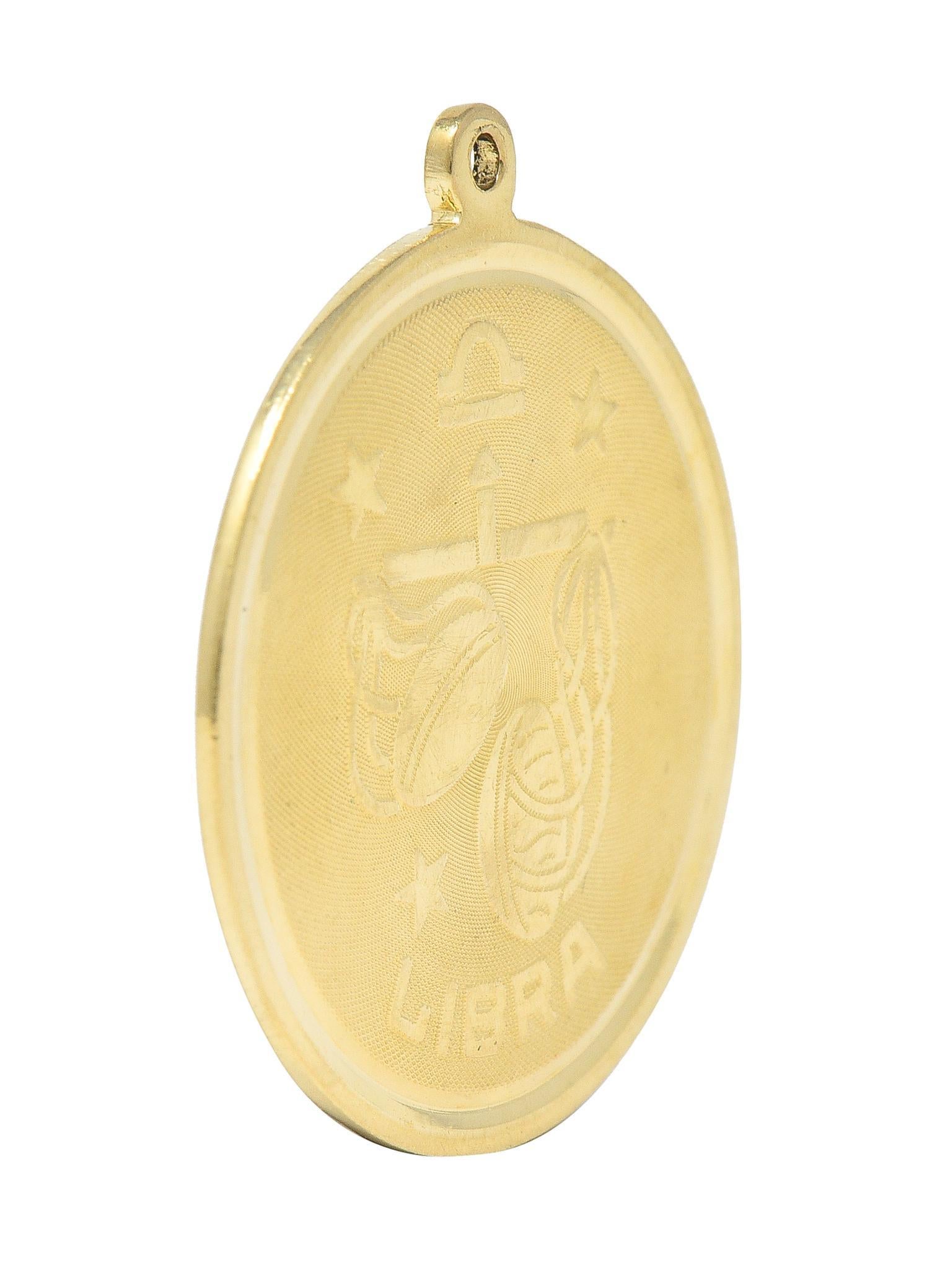 Designed as a round disk with high polished edges and a raised Libra zodiac motif
With the astrological Libra symbol, stylized scales, stars, and inscribed 'Libra'
With a finely cross-hatch textured recess
Completed by pierced bale
Tested as 14