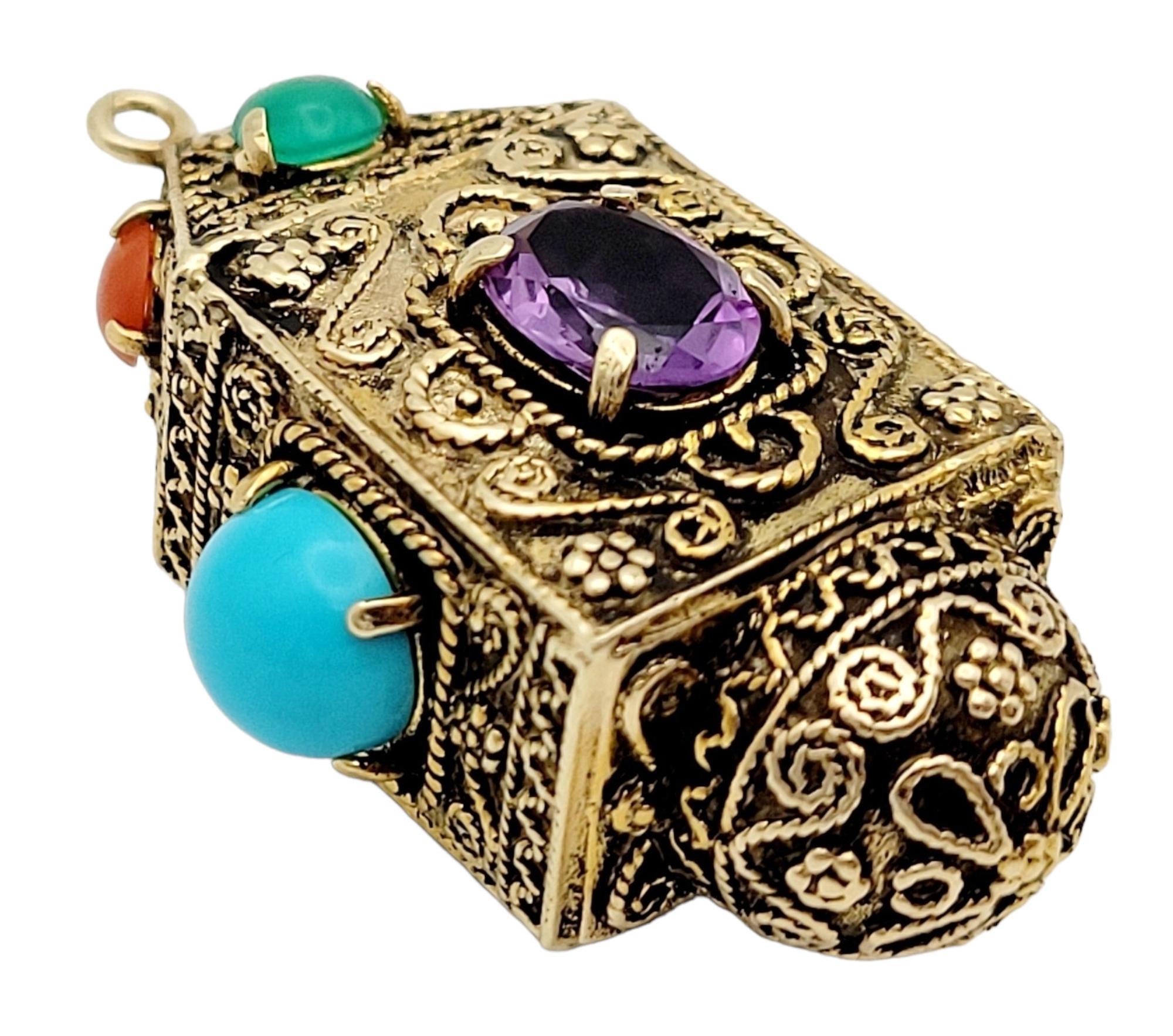 Presenting a stunning vintage amulet pendant crafted in yellow gold and adorned with a vibrant array of gemstones. This exquisite pendant showcases an intricately carved rectangular shape, exuding timeless elegance. The pendant's vertical hanging