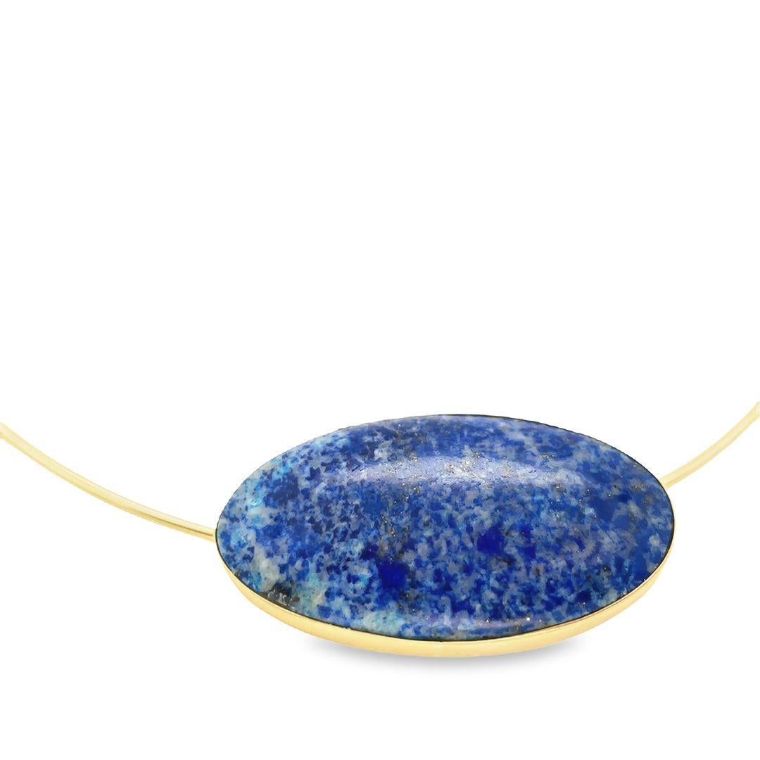 This stunning wire collar necklace features a bezel-set Lapis Lazuli, set in 14K yellow gold. The Lapis Lazuli is a large gemstone, measuring 1.55 inches, with a total weight of approximately 32.00 carats. The bezel setting is oriented East to West,