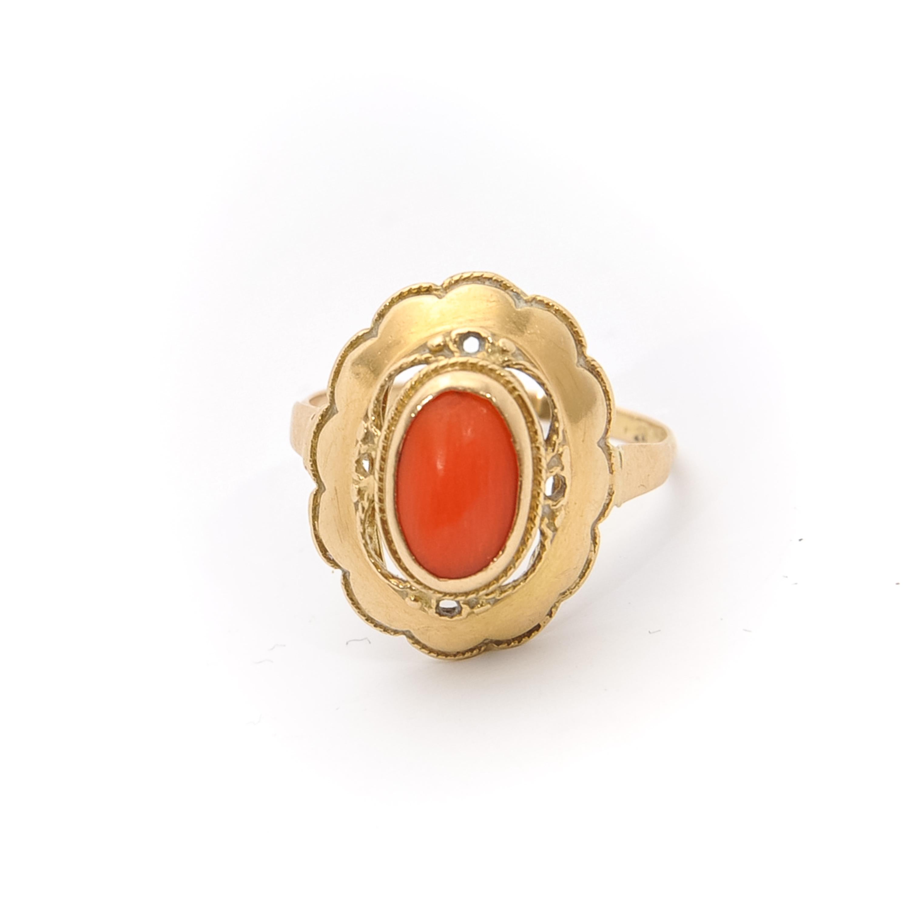 A vintage 14 karat gold ring set with a natural cabochon coral in a rich openwork frame. The oval-shaped gold ring featuring a beautifully scalloped border.

The *coral ring is in beautiful condition. Marked. Tested as 14k gold. 

Measurements: H
