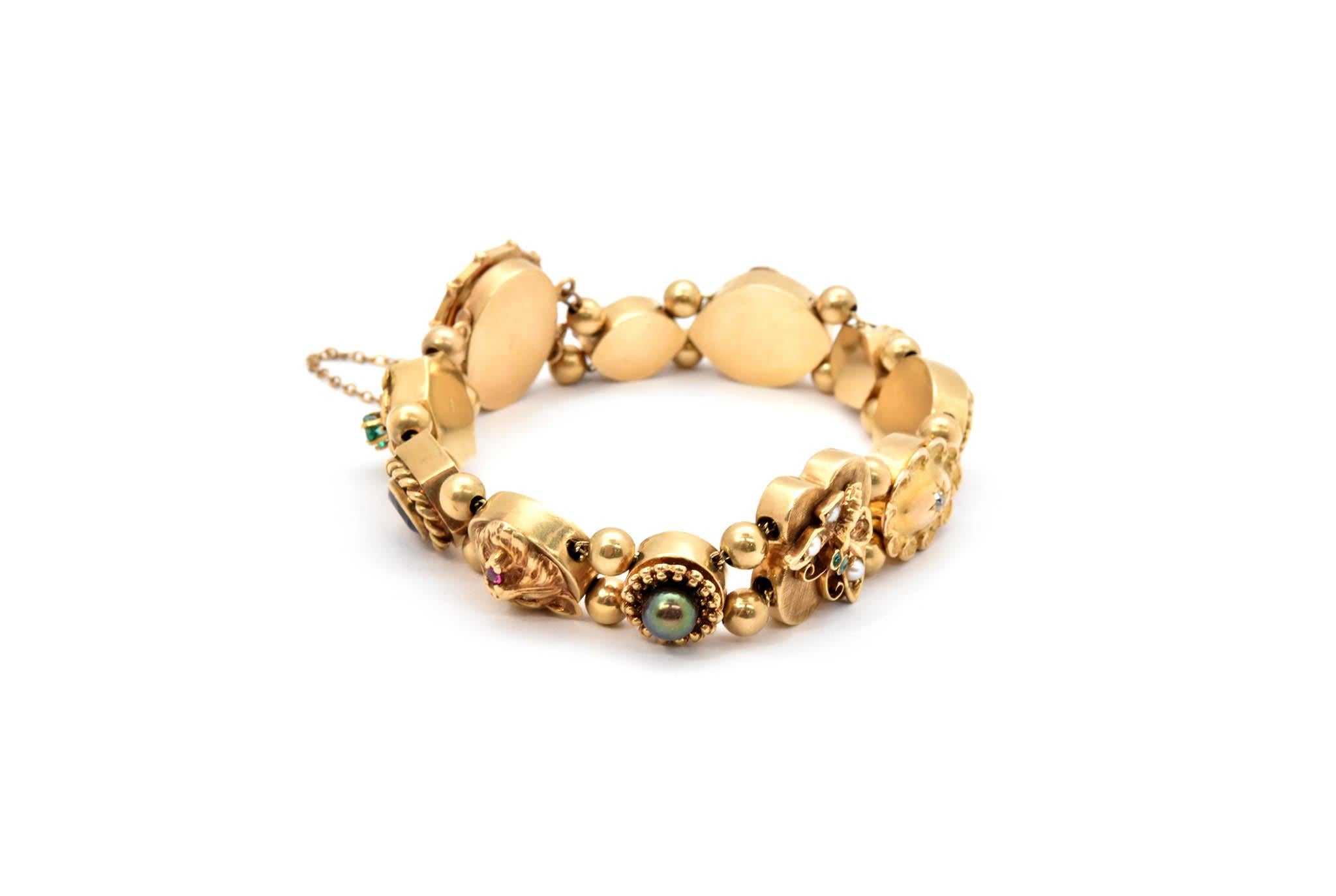 This vintage bracelet brings classic design into the 21st century. The bracelet is made in solid 14k yellow gold, and it features sliding charms with various gemstones and designs including: owl, butterfly, opal, pearl and emerald. The bracelet