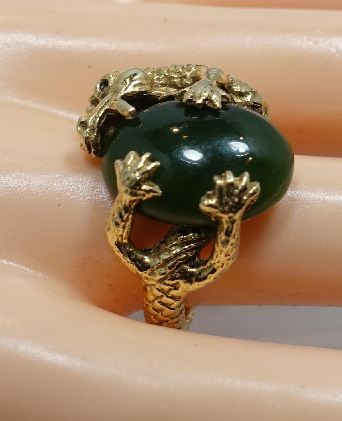 This vintage ring features an intricately carved alligator wrapped around a cabochon green jade stone in a 14 Karat gold setting.  It’s a size 7-1/2 and this ring measures 3/4” x 3/4” and is in excellent condition.