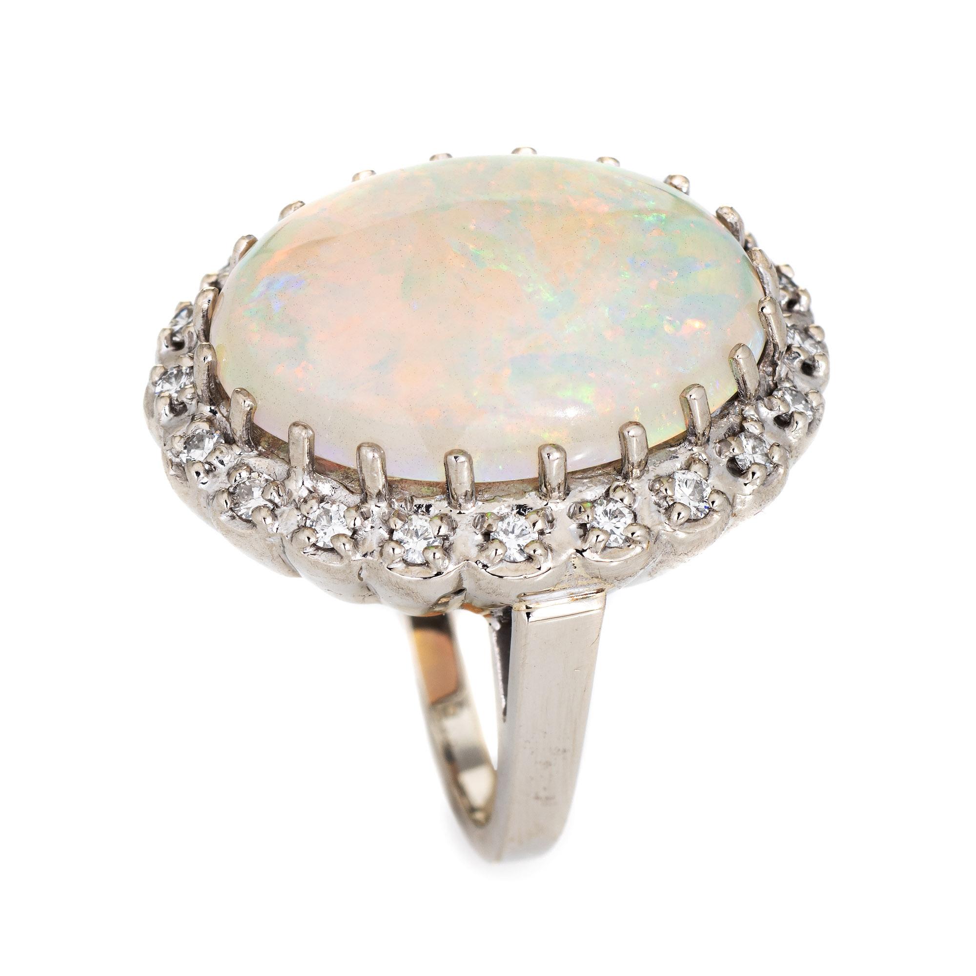 Stylish vintage opal & diamond cocktail ring (circa 1970s to 1980s) crafted in 14 karat white gold. 

Natural opal measures 20mm x 15mm (estimated at 14.50 carats) is accented with 20 estimated 0.02 carat round brilliant cut diamonds. The total