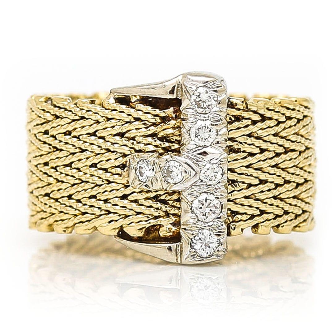 A stylish vintage 14ct yellow gold and brilliant cut diamond buckle ring dating from circa 1990. The head of the ring has white gold buckle set with seven brilliant cut diamonds totalling approx 0.15ct of good colour and clarity. The shank itself is