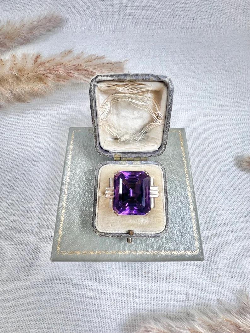 Vintage Cocktail Ring

14ct Gold Tested

Circa 1940s

This vintage cocktail ring is a stunning piece of jewellery that is bound to turn heads. It is crafted from 14ct yellow gold and features a huge 20ct amethyst stone that is sure to capture