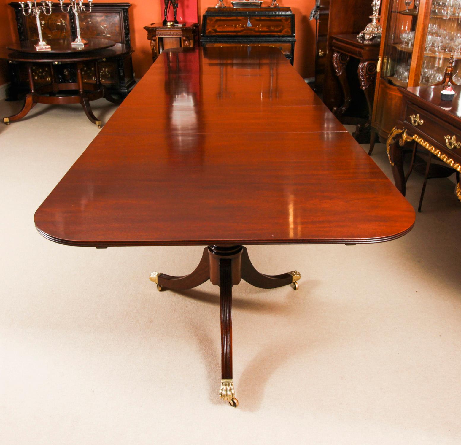 This is a superb large Vintage handmade triple pedestal dining table in elegant George III style, by the master cabinetmakers Arthur Brett & Son, Norwich, crafted in flame mahogany, dating from the mid-20th century.

Capable of seating sixteen