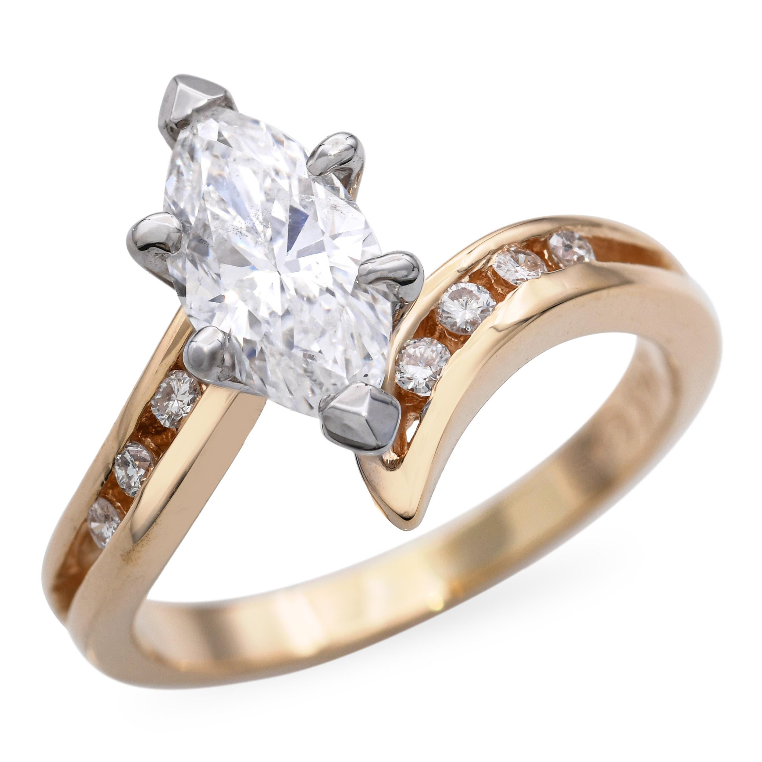 Dieser Bypass-Verlobungsring im Vintage-Stil besticht durch sein zeitloses Design mit romantischem Touch. Er ist aus 14-karätigem Gold gefertigt und zeigt zwei runde Brillanten von insgesamt 1,01 Karat, die sich in einer Bypass-Fassung anmutig