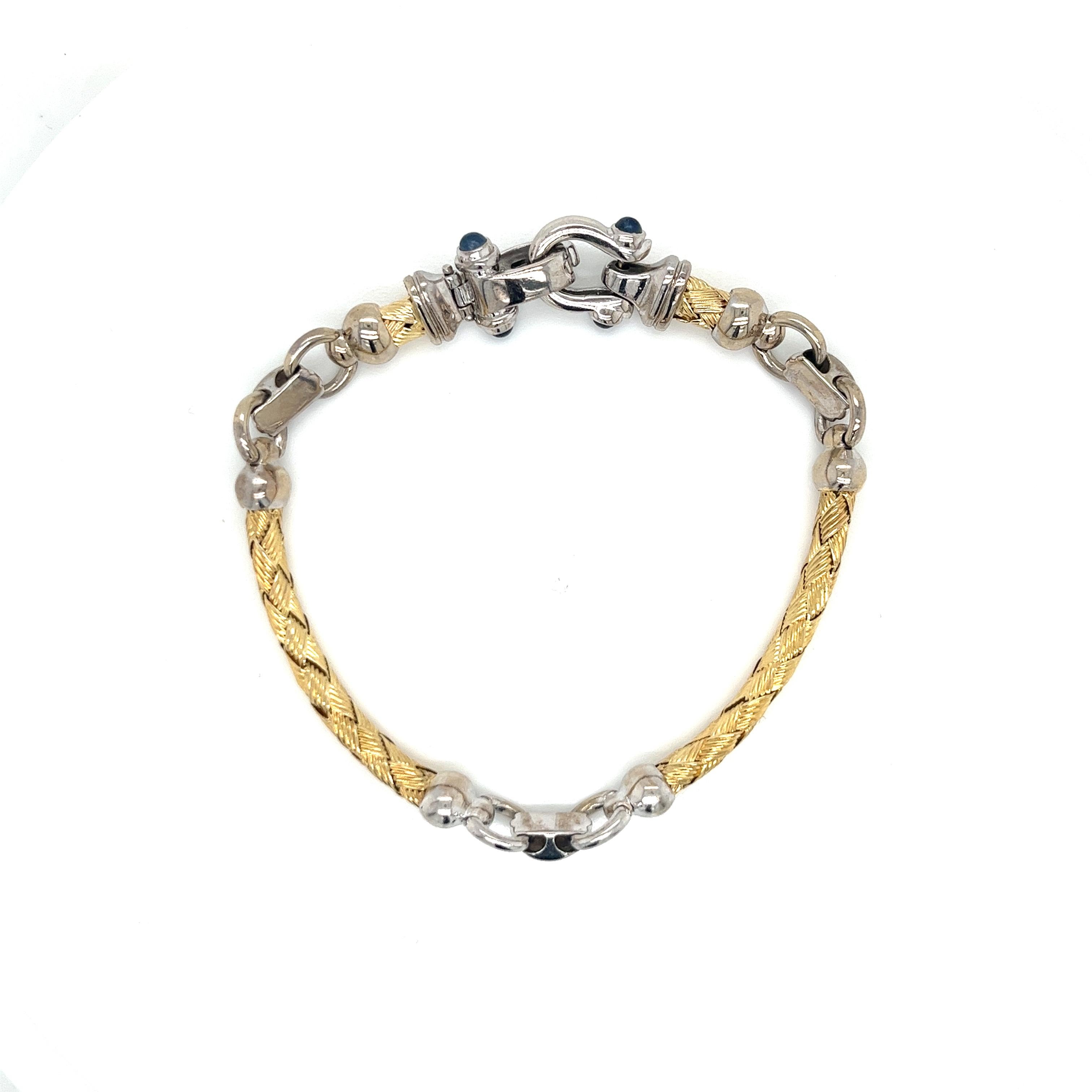 This exquisite vintage bracelet from the 1990s boasts a timeless elegance with its 14k two-tone gold design. Weighing 21.15 grams, the piece features intricately woven 14k yellow gold curved bar links, seamlessly interspersed with sleek white gold