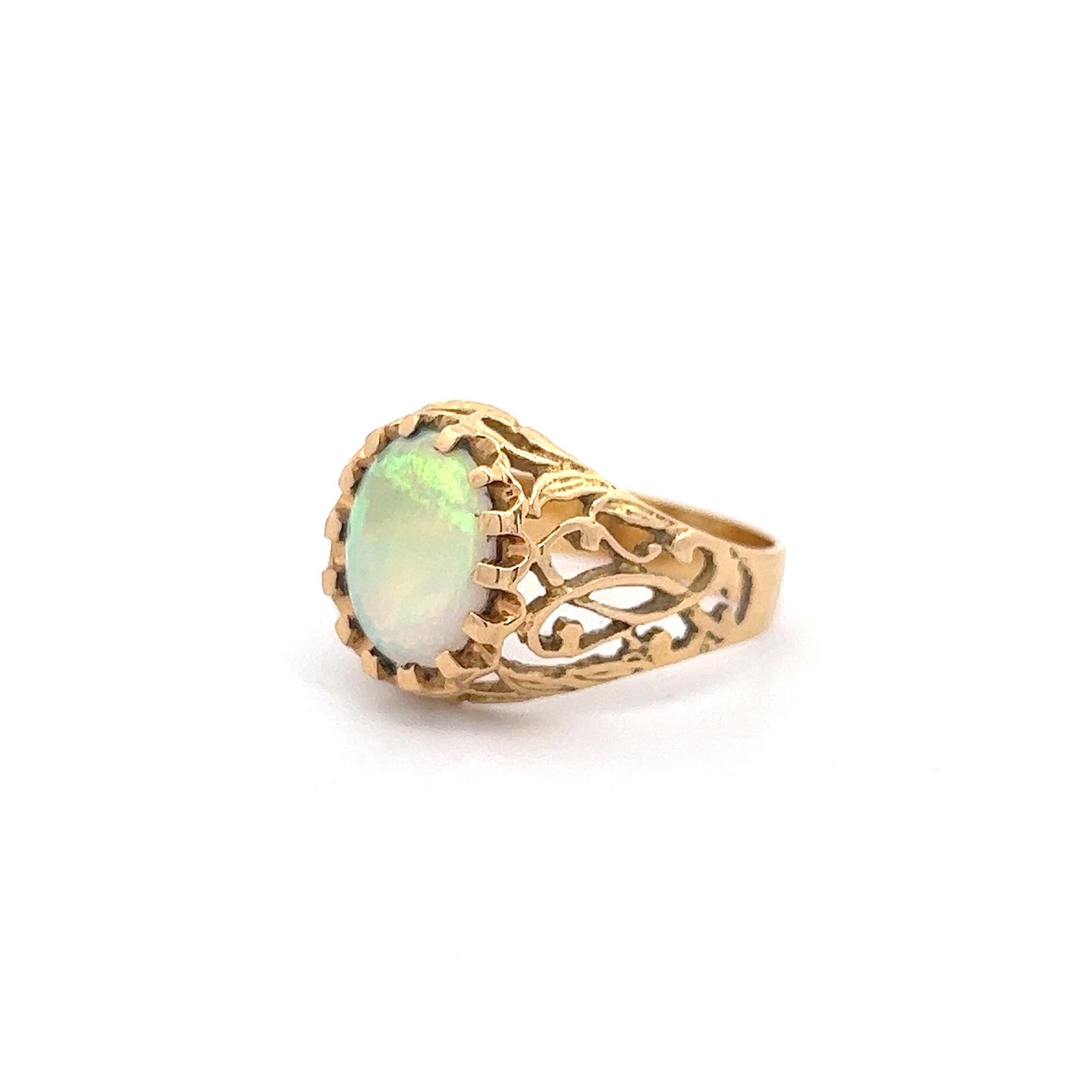 An exceptional opal with wonderful fire proudly set in a brutalist-era 14k yellow gold ring, size 8. The opal is of Australian origin and weighs approximately 1.11 carats (measured in setting). The ring shows minor signs of wear on the shank in the