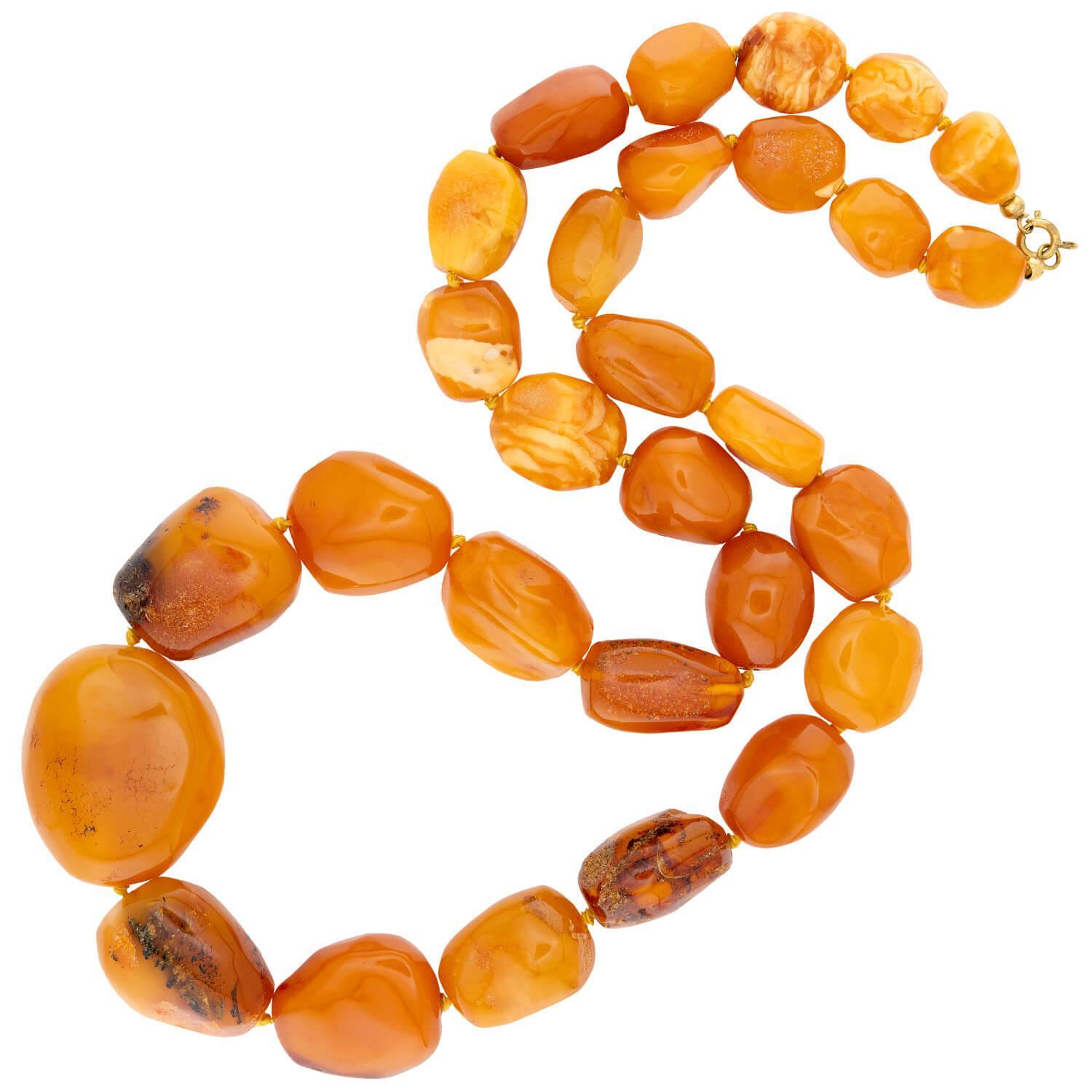 Un favoloso filo di perline d'ambra dell'epoca Vintage (ca. 1960)! Questa meravigliosa collana è composta da 29 perle di ambra baltica color burro, infilate a mano su un filo giallo per formare un'incantevole collana. Le perle d'ambra variano per