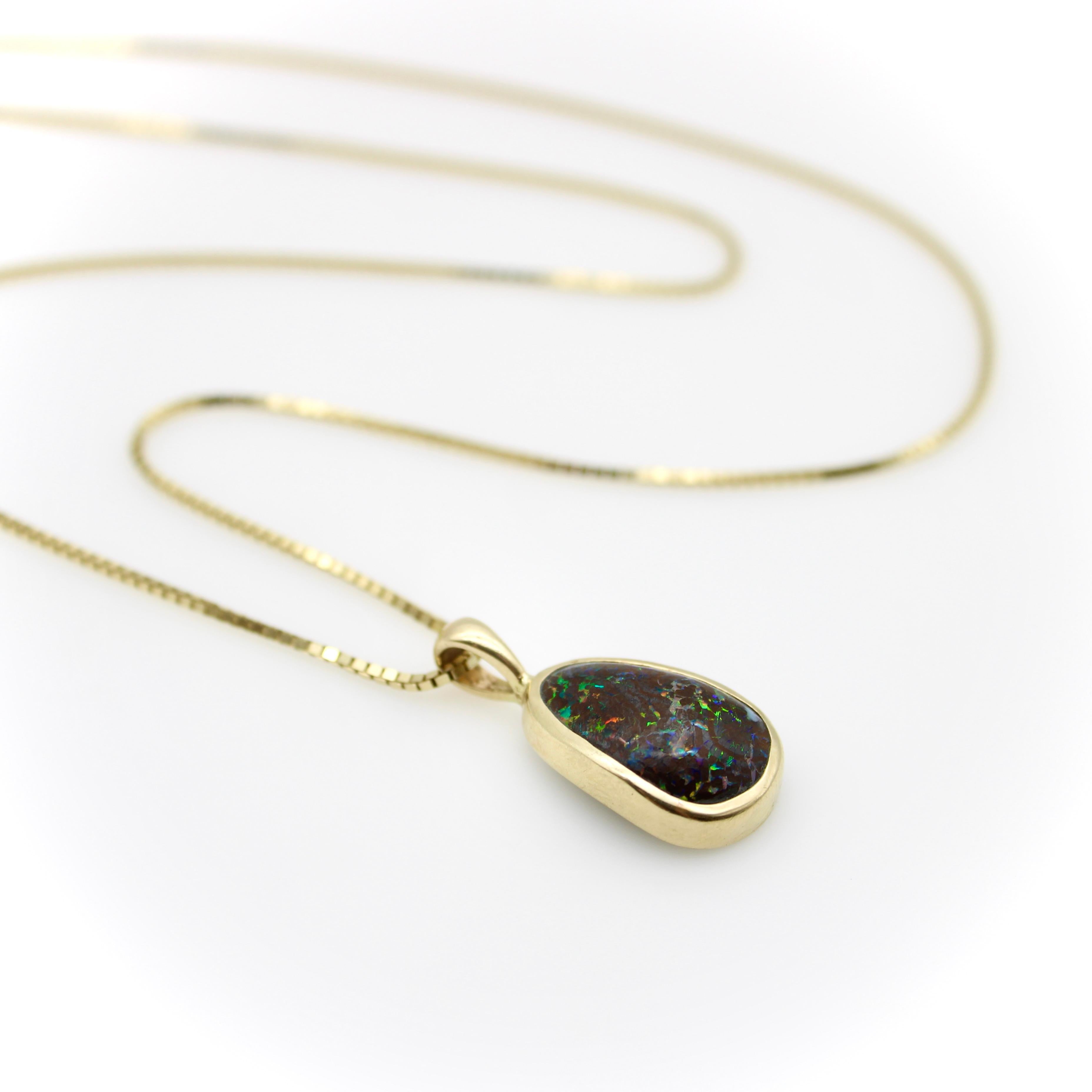 This organic form boulder opal has a pleasing, rounded triangular shape. It is bezel set with a custom bezel that gracefully hugs the form of the opal. Boulder opals are special because of their bright and vibrant colors that swirl like a galaxy