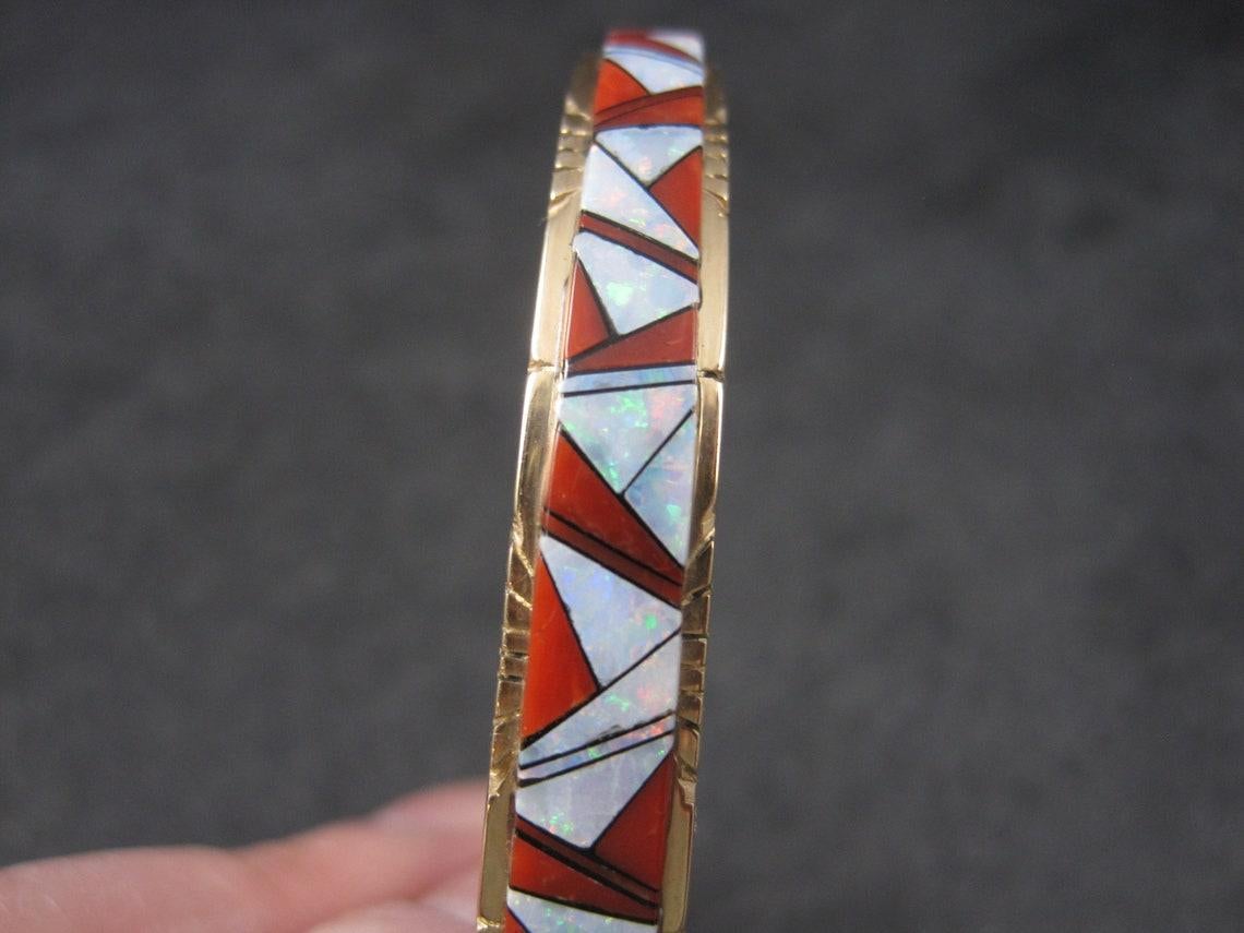 This gorgeous vintage cuff bracelet is solid 14k yellow gold.
It features intricate inlay in bright red coral, natural opal and jet.
The opal has much more flash than the photos portray.

This bracelet tapers from 7/16 to 1/4 of an inch.
It has an