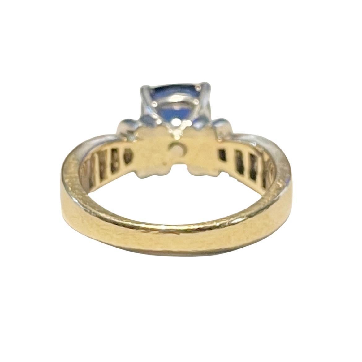 Here we have a classic two tone retro design. This yellow gold tapered shanks taper out and in at the top and bottom of the ring. In the center of the shanks are channel set baguettes giving the ring a dynamic design. In the center is a white gold