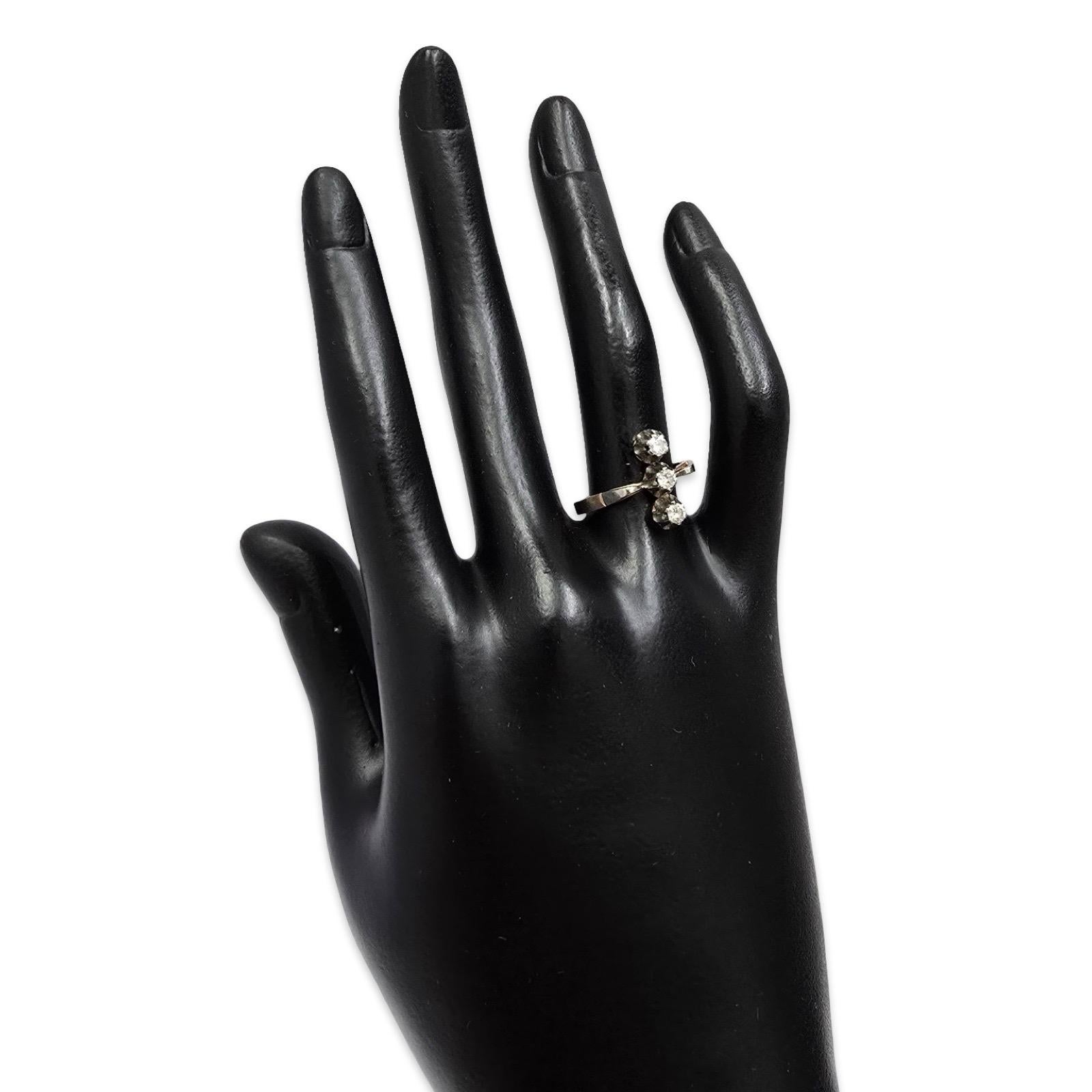 Bague vintage raffinée à trois pierres en or massif 14 carats, sertie de trois diamants ronds brillants dans des montures cannelées sculptées. Les pierres sont disposées en une élégante ligne verticale, s'élevant gracieusement le long du doigt dans