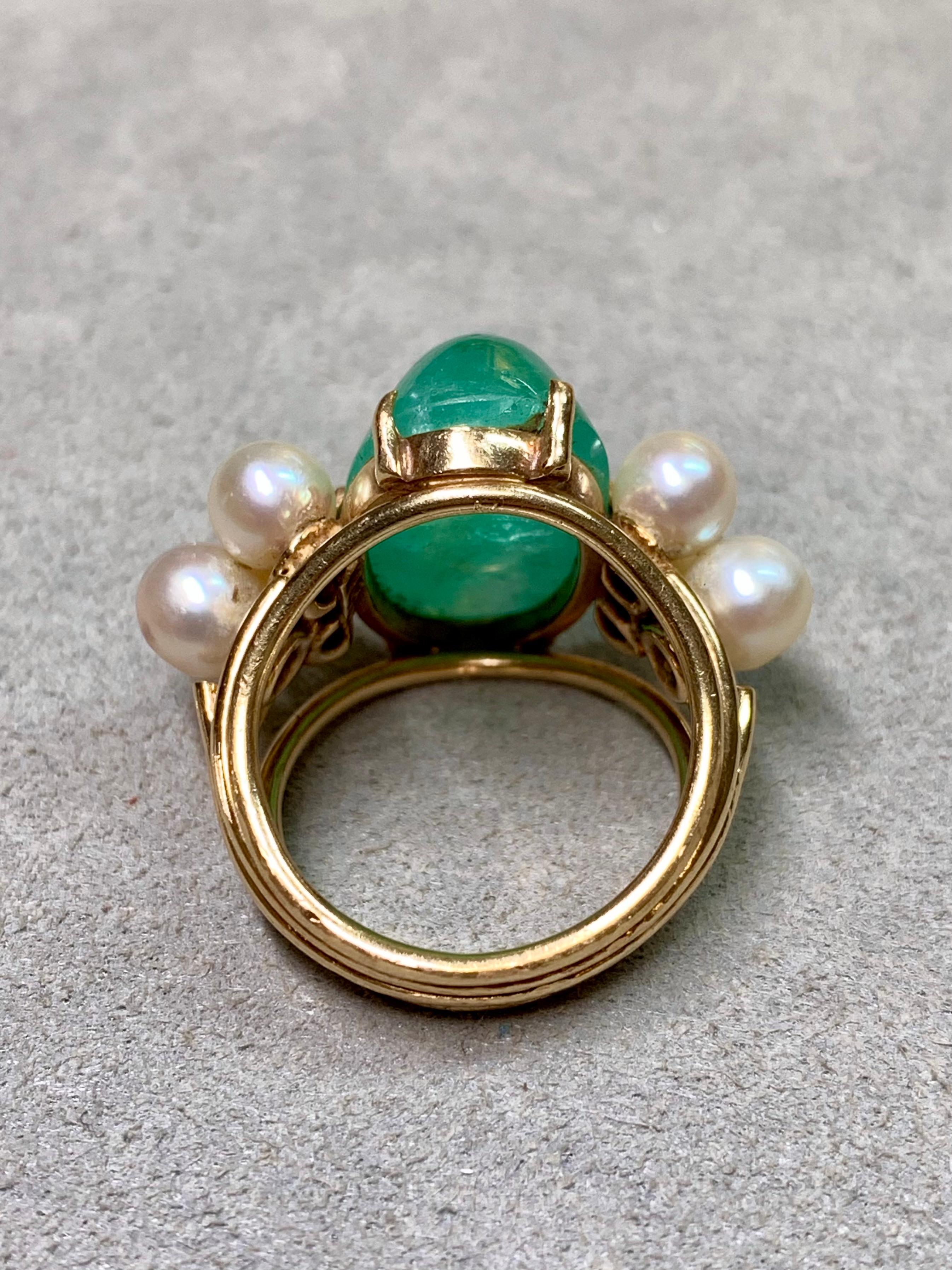 A captivating vintage ring from the 1970s, crafted in warm 14K yellow gold. At its center rests an impressive elongated cabochon emerald weighing approximately 14.80 carats, believed to be of Brazilian origin and exhibiting a vivid green hue.