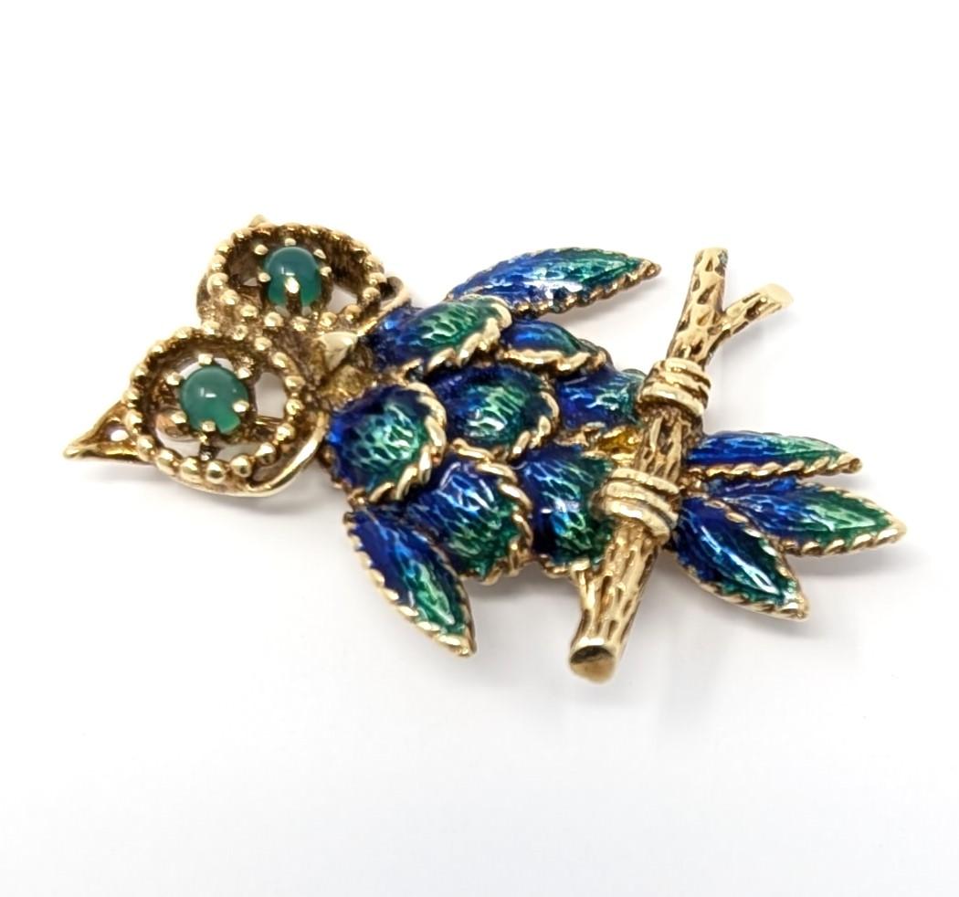Fabulous vintage owl brooch, featuring vibrant green and blue enamel set in solid 14k yellow gold. Features green glass eyes, this would make a wonderful gift for owl lovers! Measures 1 inch in width by 1.5 inches in length and is signed 14K TCJI on