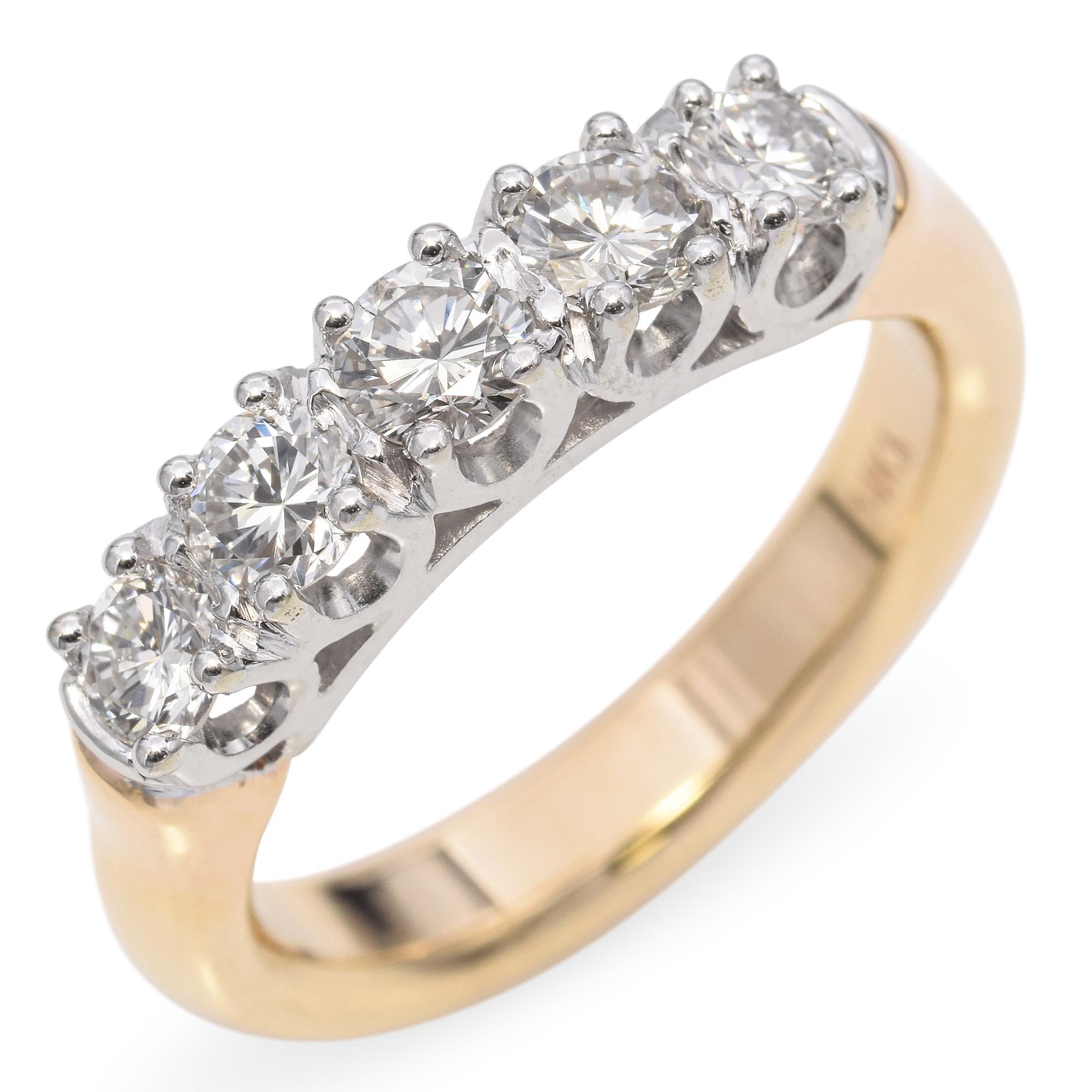 Une bague à bandeau de diamants raffinée, présentant une série de diamants ronds brillants sertis dans de l'or blanc 14k, complétée par un bandeau en or jaune.

Poids : 6,4 grammes 
Pierre : 1.1tcw Brilliante ronde 
Qualité de la pierre : G-H,