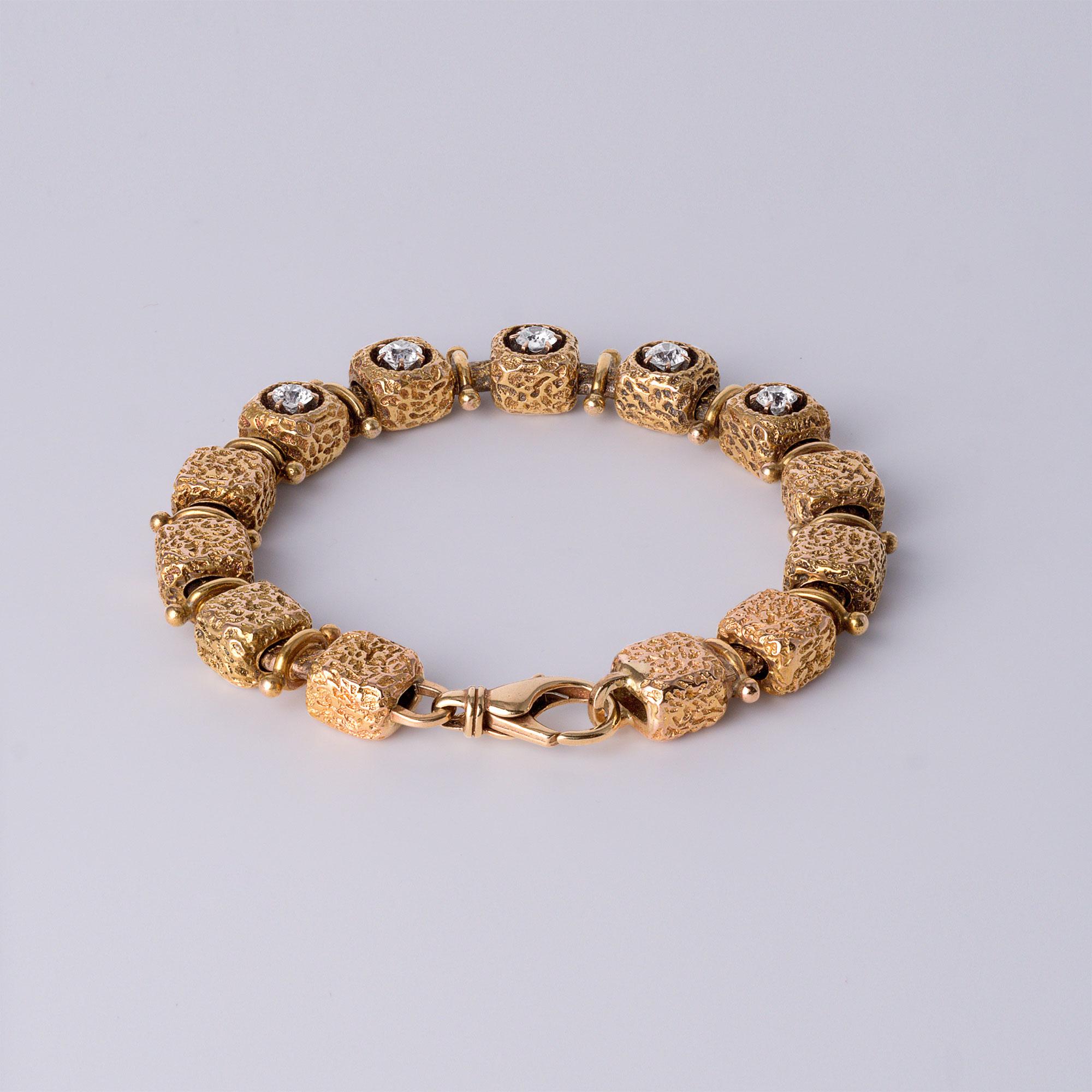 Un raro mix di fascino antico ed eleganza modernista, questo bracciale vintage unico nel suo genere mette in mostra un'eccezionale maestria e un design sofisticato. Realizzato in solido oro giallo 14 carati, il braccialetto presenta cinque