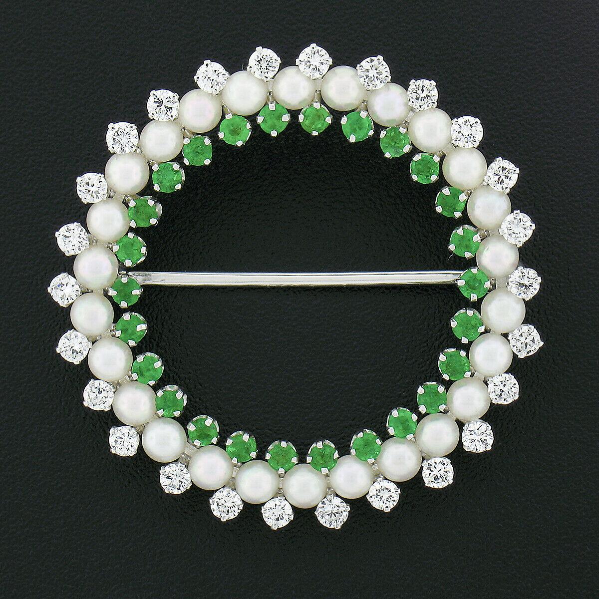 Here we have a truly marvelous vintage wreath pin brooch that was well crafted from solid 14k white gold. This incredible brooch consists of fine diamonds, emeralds, and pearls that are neatly set granting a very classy and elegant design. The inner