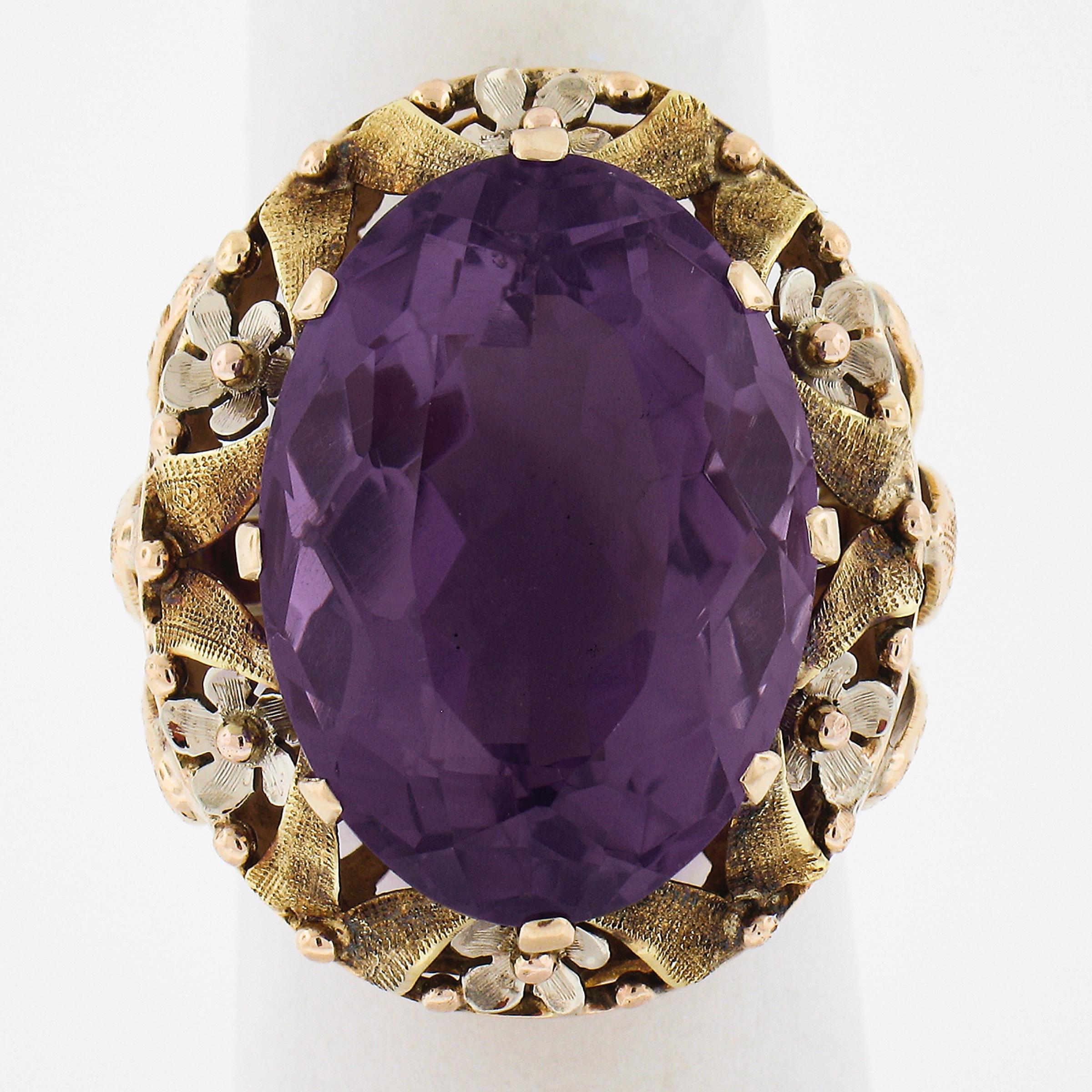 --Stone(s):--
(1) Natural Genuine Amethyst - Oval Cut - Multi-Prong Set - Rich Purple Color - 20.5x15mm - 16.3ct (approx.)

Material: Solid 14k Rosy Yellow Gold w/ White Gold Flowers & Green Gold Leaves
Weight: 13.1 Grams
Ring Size: 6.0 (Fitted on a