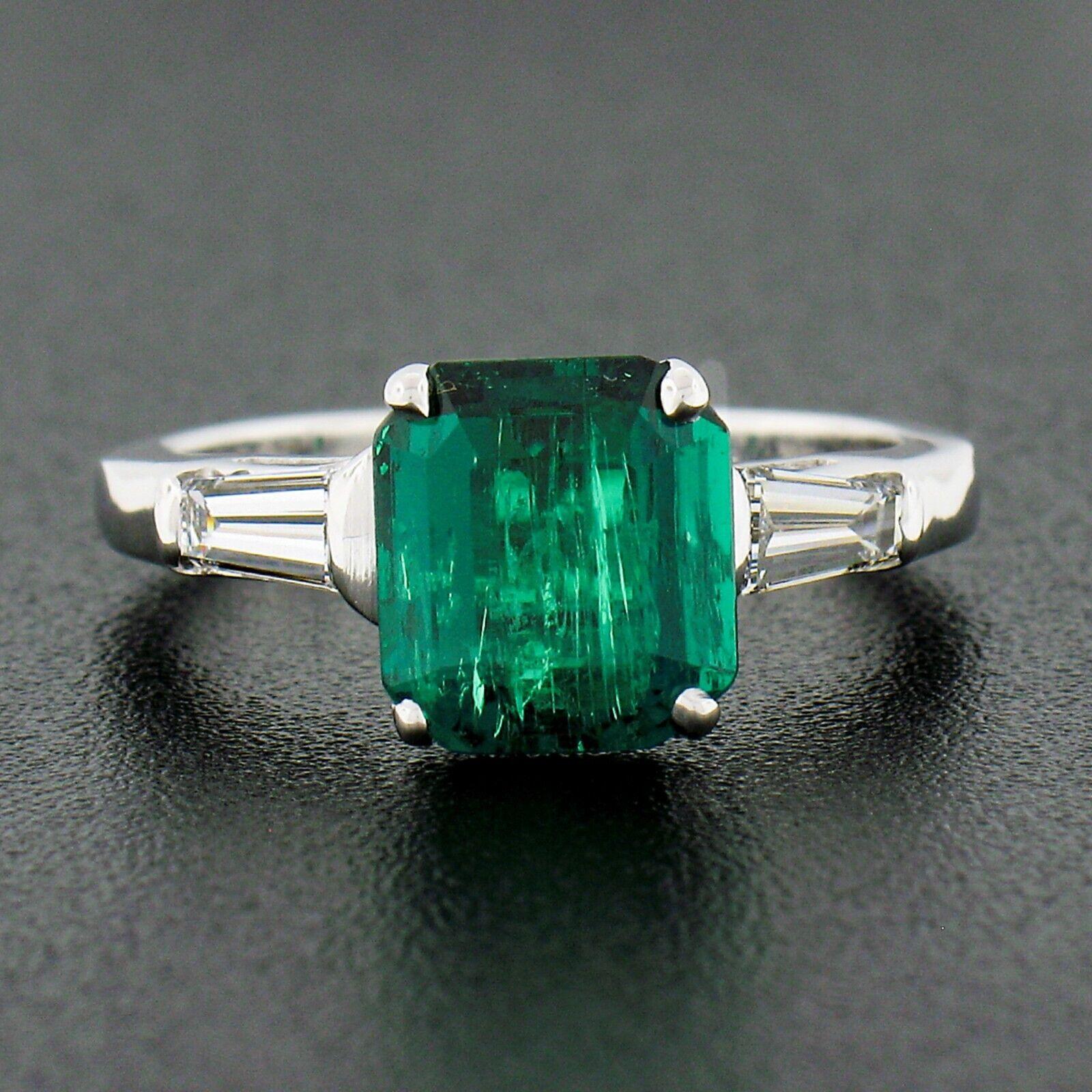 This stunning, GIA certified, Colombian emerald and diamond vintage engagement ring is crafted in solid 14k white gold. The ring features a breathtaking, natural, octagonal step cut emerald stone that displays the finest and most desirable rich