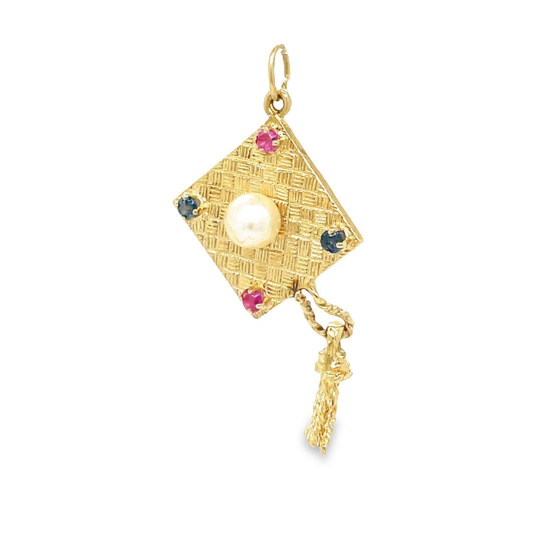 Celebrate graduation day in style with this beautiful 14K vintage charm. This unique charm features a graduation cap design, complete with a lovely natural pearl on top and a movable tassel. Adorned with (2) 2.7 mm Rubies and (2) Blue Sapphires,