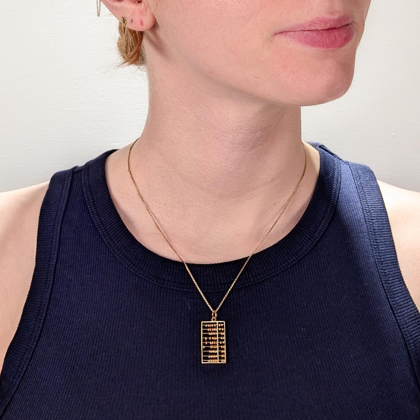 A fine vintage figural gold charm.

In 14 karat yellow gold.

In the form of an abacus or counting frame with moving beads.

With an integral bail and jump ring.

Simply a wonderful charm or pendant for the mathematically minded!

(Chain for display