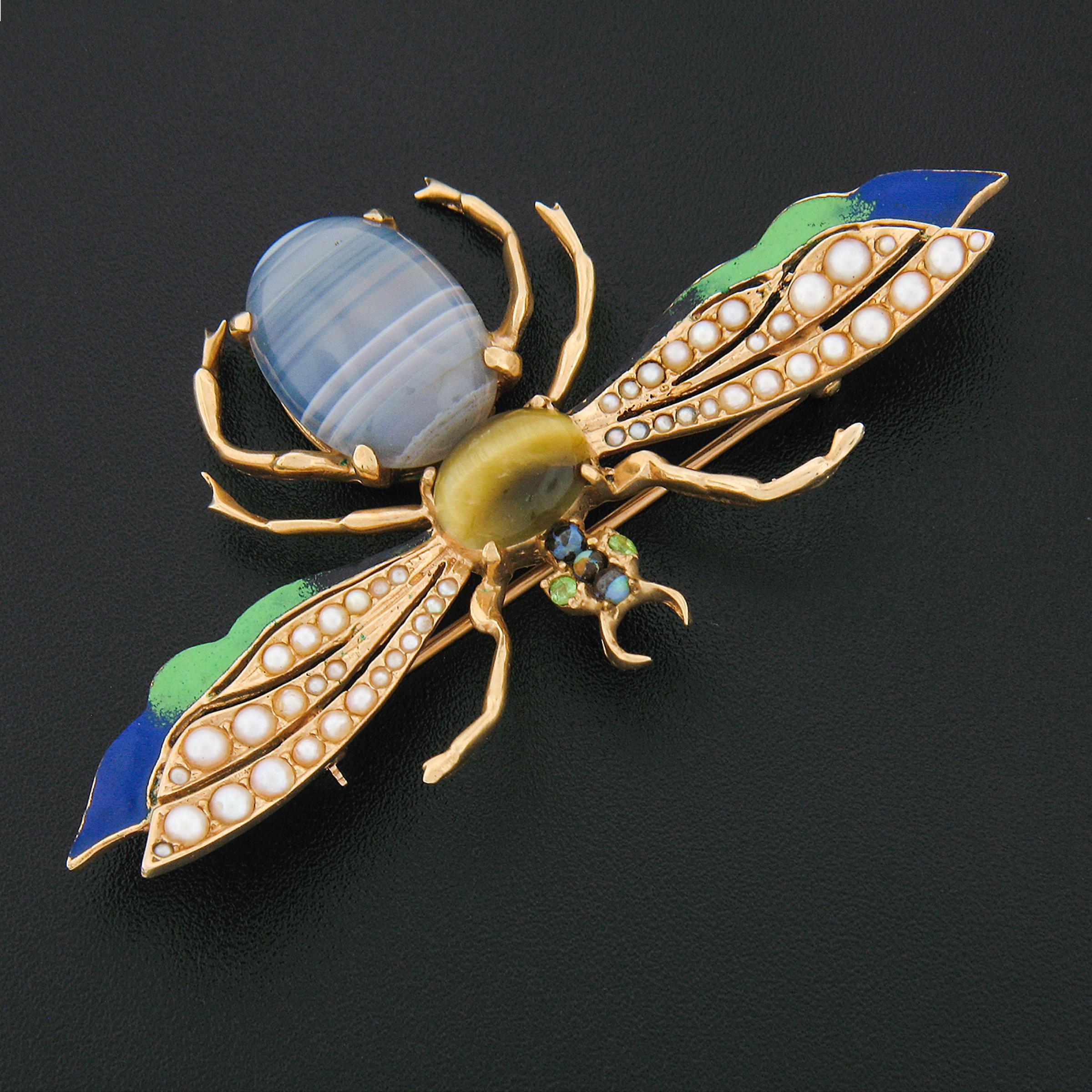 You are looking at a unique, very well-made, vintage brooch crafted in solid 14k yellow gold. The design features a large fly set with a genuine banded agate, and tigers eye at its body. The wings are adorned with lovely seed pearls and gorgeous