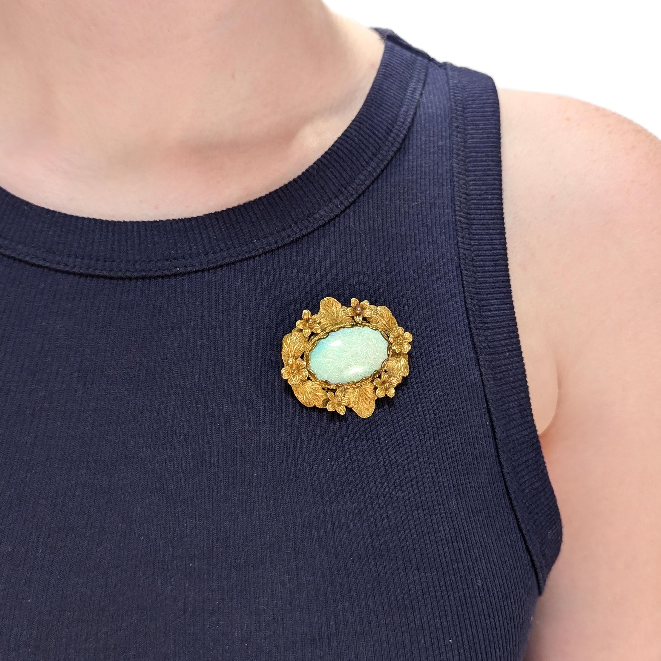 Eine schöne Vintage-Brosche aus Gold und Opal.

Aus 14 Karat Gelbgold.

Zentriert auf einem großen ovalen Opal-Cabochon.

In einer Fassung aus gebürstetem Gold mit figuralen Blumen- und Blattmotiven. 

Mit Scharnierstift und C.C.-Verschluss auf der