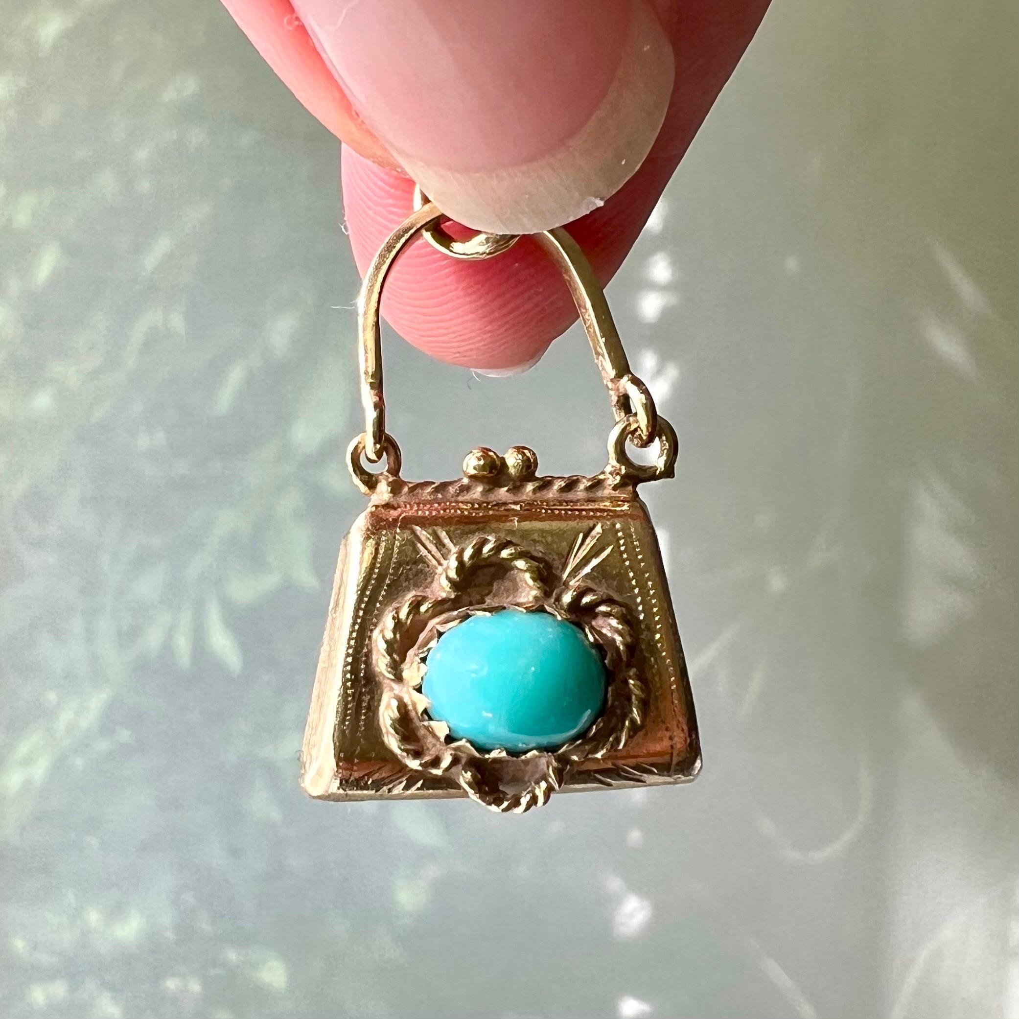 A lovely vintage purse charm pendant created in 14 karat gold and set with turquoise stones. The gold purse is beautifully designed with two oval turquoise stones on each side and the gold is created with matted satined gold on the sides. The purse