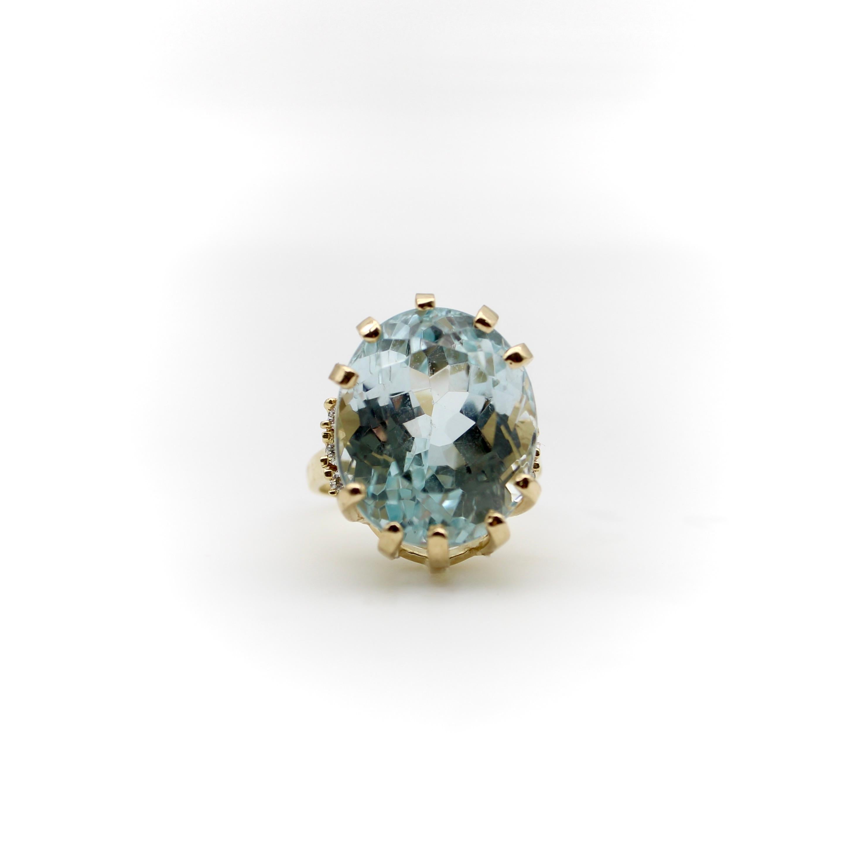 The stunning ice blue aquamarine stone in this ring is a large mixed oval cut, deep with many facets that can be admired while looking into the ring. The depth of the stone creates a beautiful cocktail ring with elegant height. The 14k gold setting