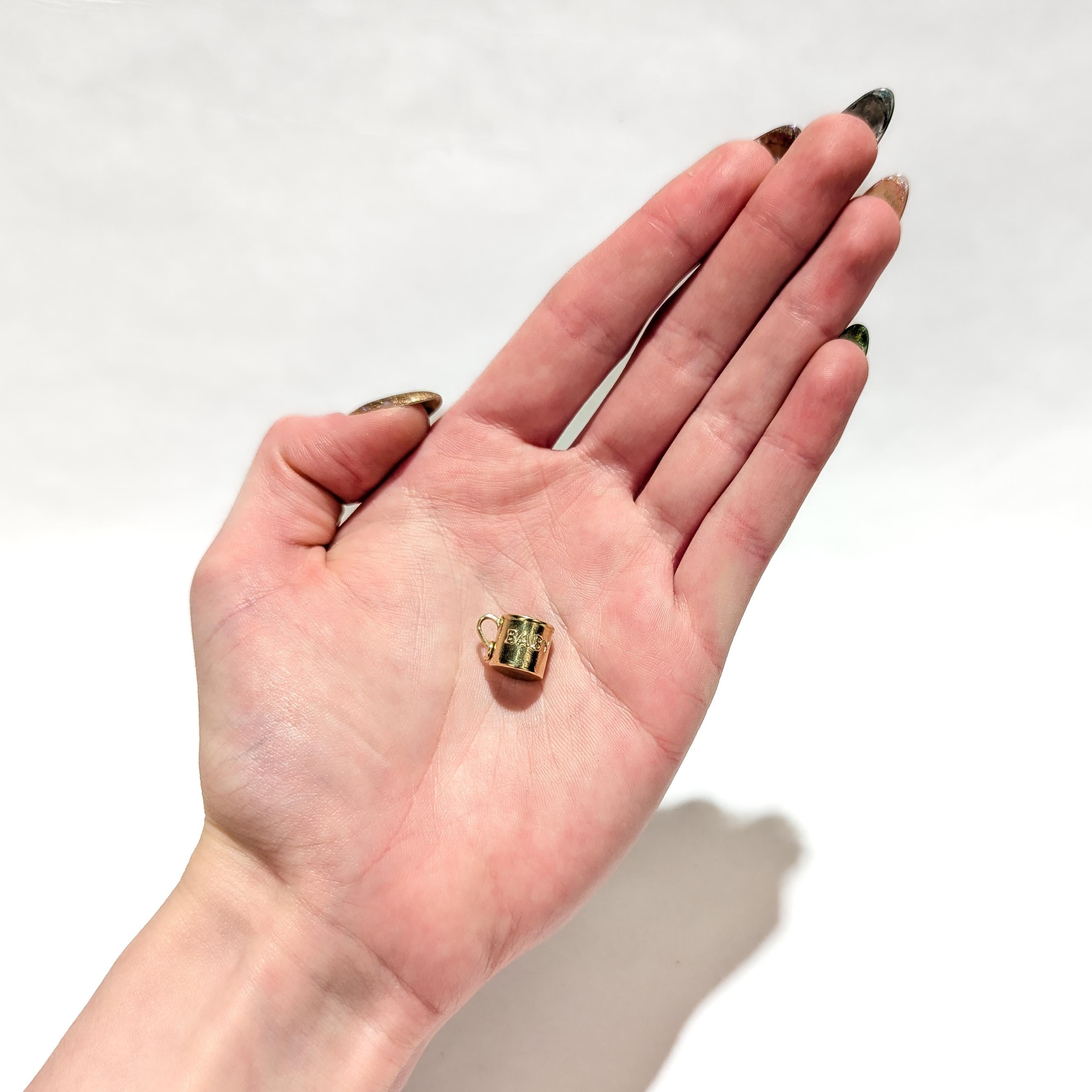 A fine vintage gold charm for a charm bracelet.

In 14 karat yellow gold.

In the form of a a baby mug with an embossed 'BABY' to the exterior.

With a jump ring to the handle.

Simply a wonderful charm!

(Chain is for display purposes only and is