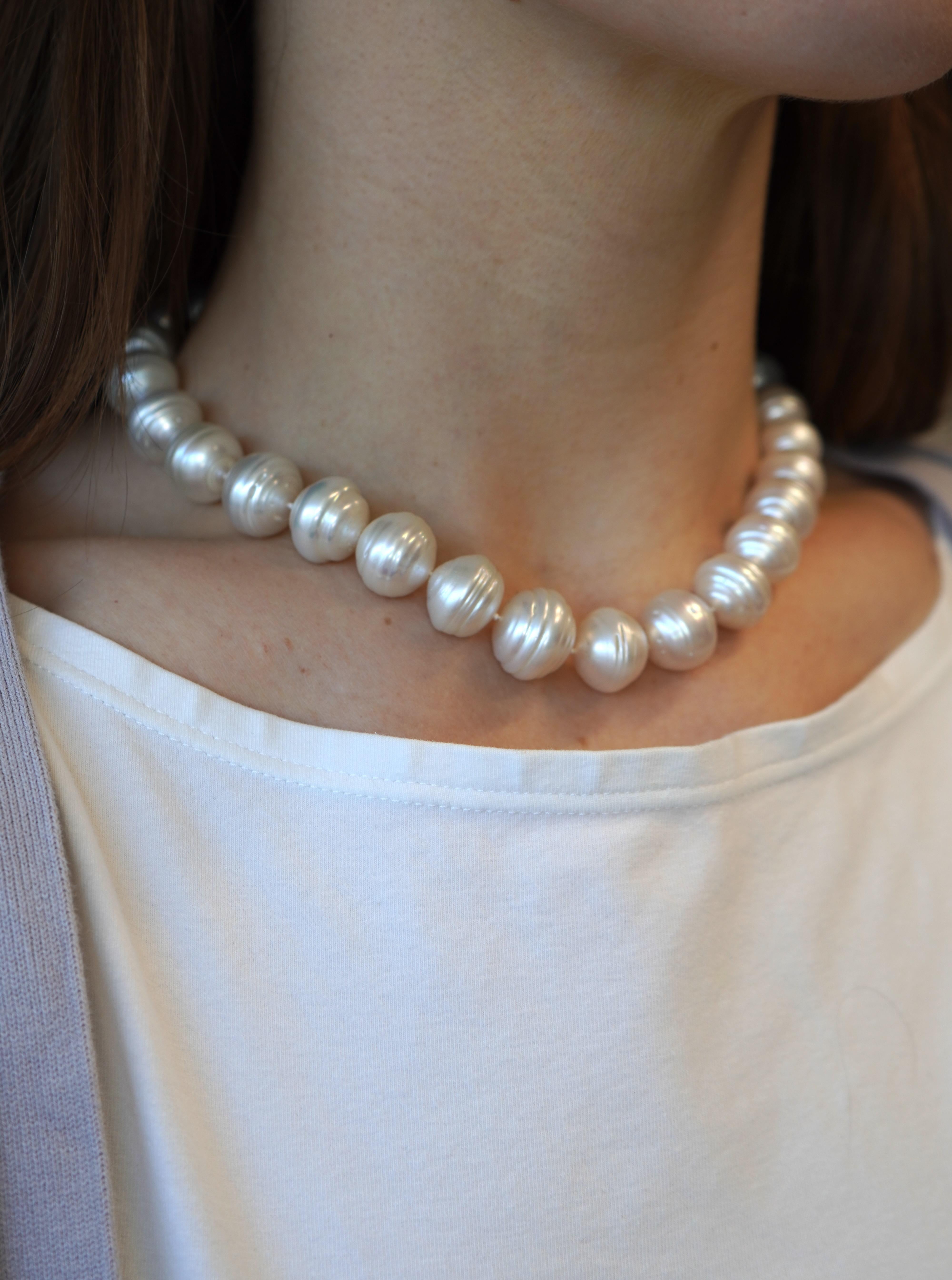 This circa 1990s baroque pearl necklace features 28 lustrous freshwater cultured pearls strung in a continuous strand. Each pearl is unique in shape and surface texture, characteristic of baroque pearls, with a subtle graduated taper. The pearls are