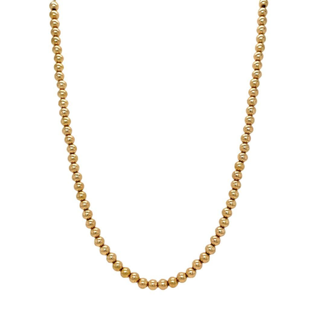 This timeless and elegant necklace featuring a bead design crafted from 14k yellow gold. The 4mm beads on this necklace catch the light, creating a playful shimmer that adds a touch of sophistication to any outfit. The beads are strung on a