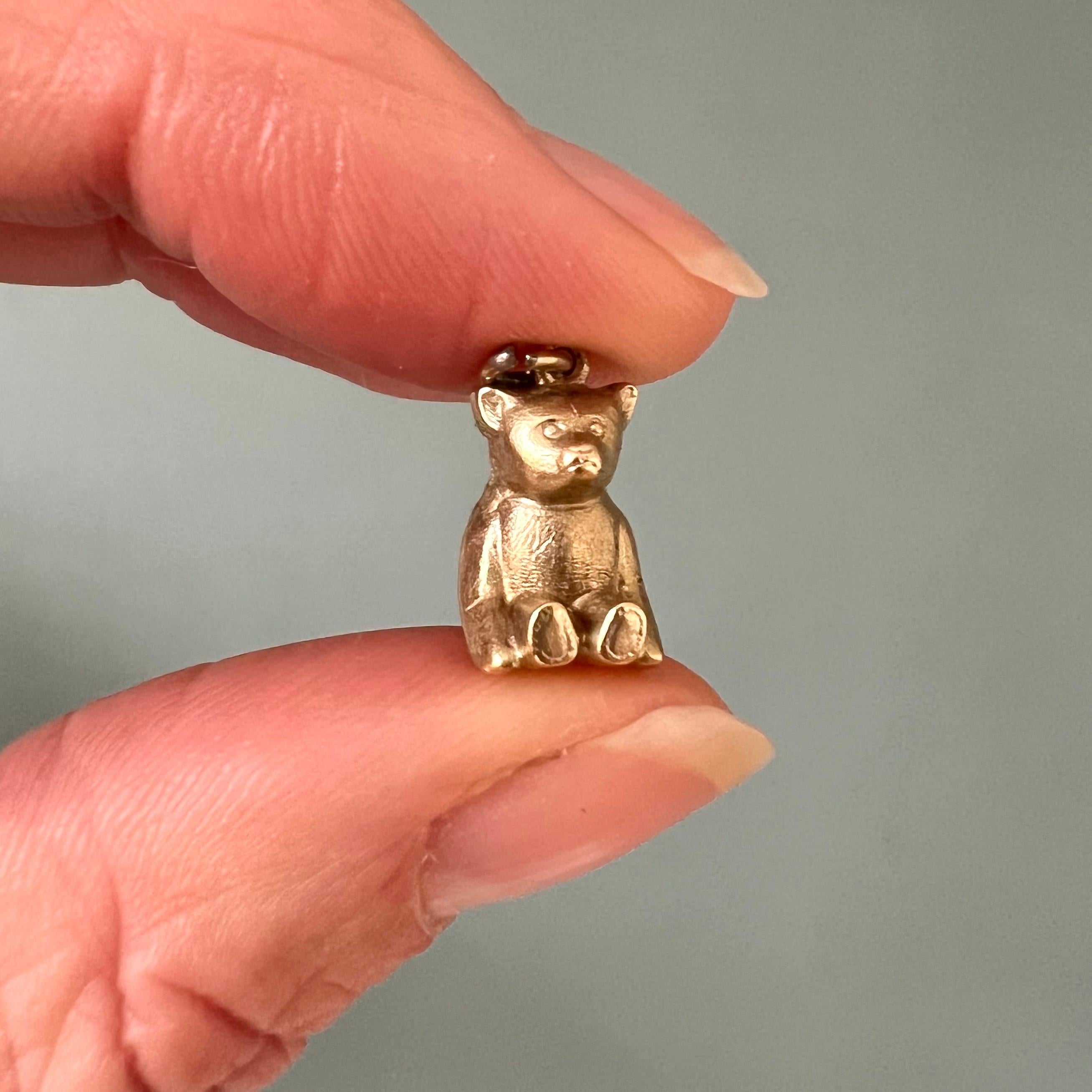 A lovely vintage 14 karat gold bear charm pendant. The charm is nicely modeled into a sweet little bear who is sitting with its paws resting next to the body. The design of the bear has a gold matte satin finish throughout his body. Will you take