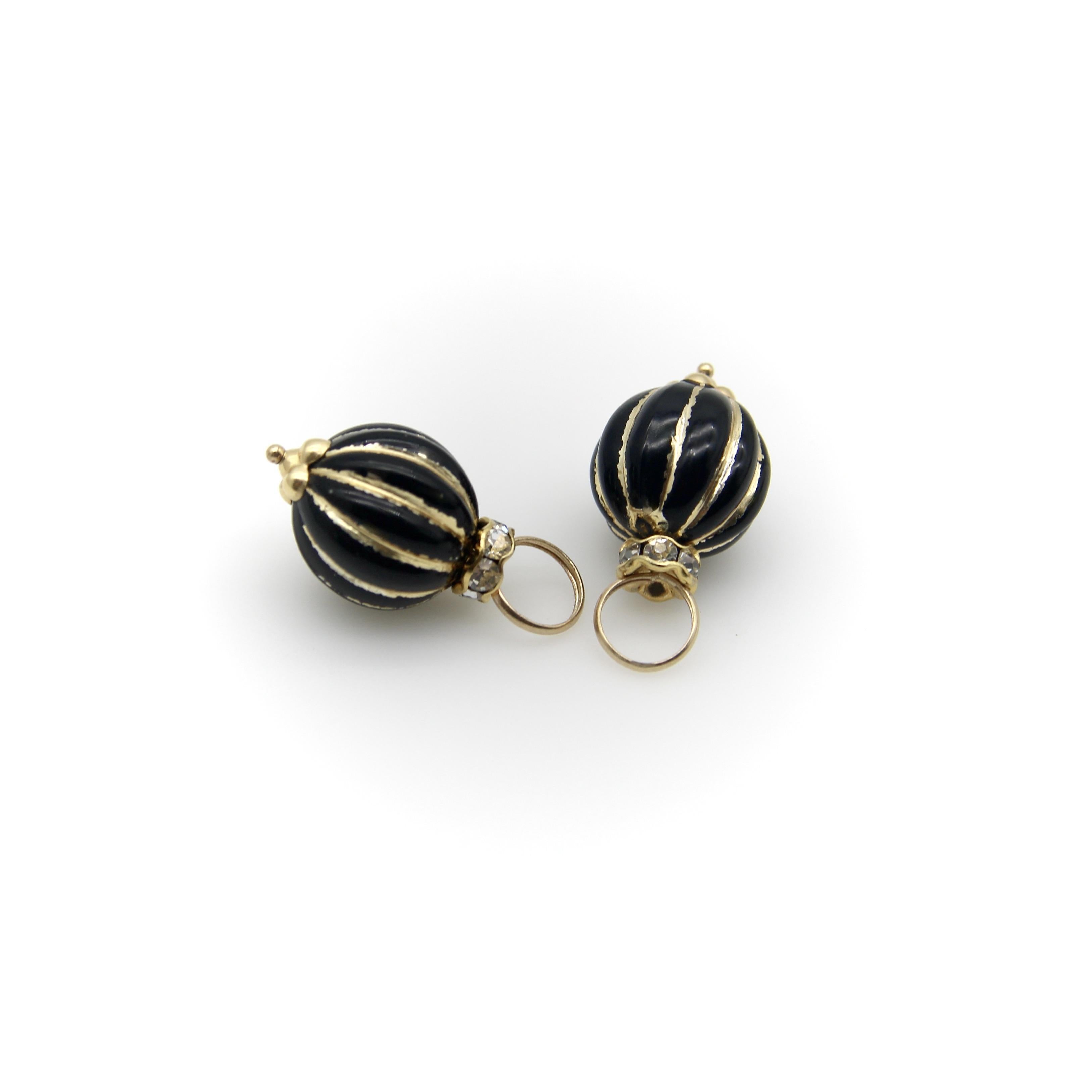 These 14k gold black enamel bead charms look great on a chain or charm bracelet—and also make perfect earring enhancers. The beads are ribbed with linear vertical gold enamel striping that makes a sharp contrast to the black beads. The beads are