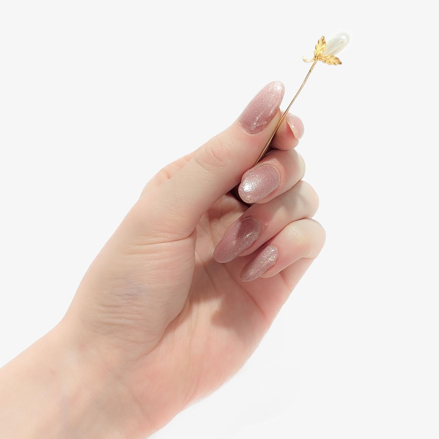 A fine vintage, figural stickpin.

In 14 karat yellow gold.

In the form of a squash or possibly an eggplant.

Set with a blister pearl flanked by two gold leaves and a stem.

Incised to the reserve with (what appears to be an owner's etched mark):