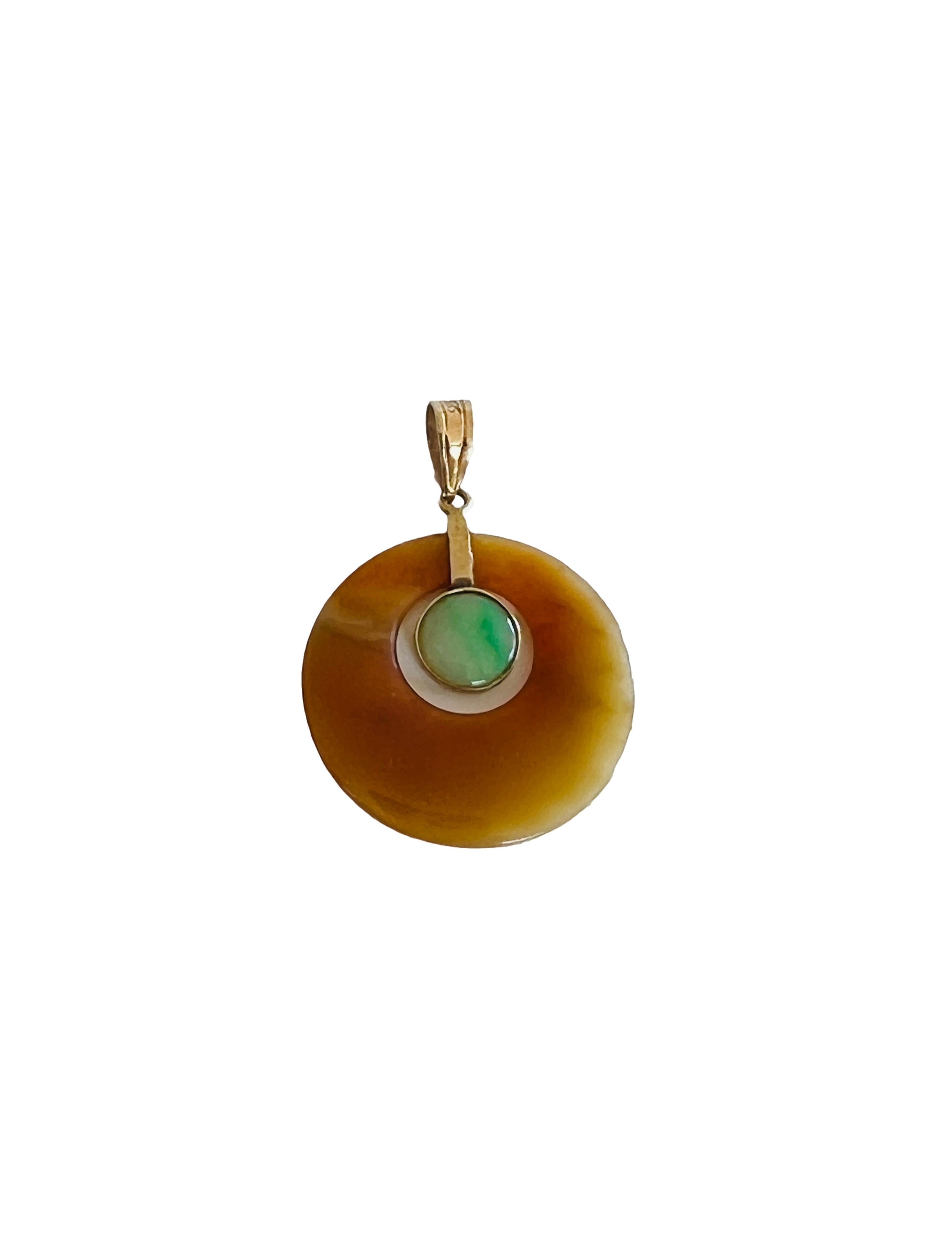 This elegant vintage pendant features a simple yet striking geometric design, showcasing a combination of light green jade and honey-toned agate chalcedony, set in a 14k gold setting. The central green jade stone stands out against the circular