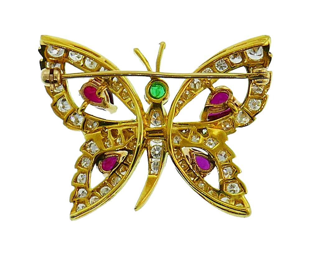 Lovely colorful pin made of 14 karat yellow and white gold, set with diamonds, rubies, and emeralds. The diamonds are round brilliant cut, G-H color VS clarity, approximately 1.50 carats total. The rubies are pear cut 1.30 carats total and round