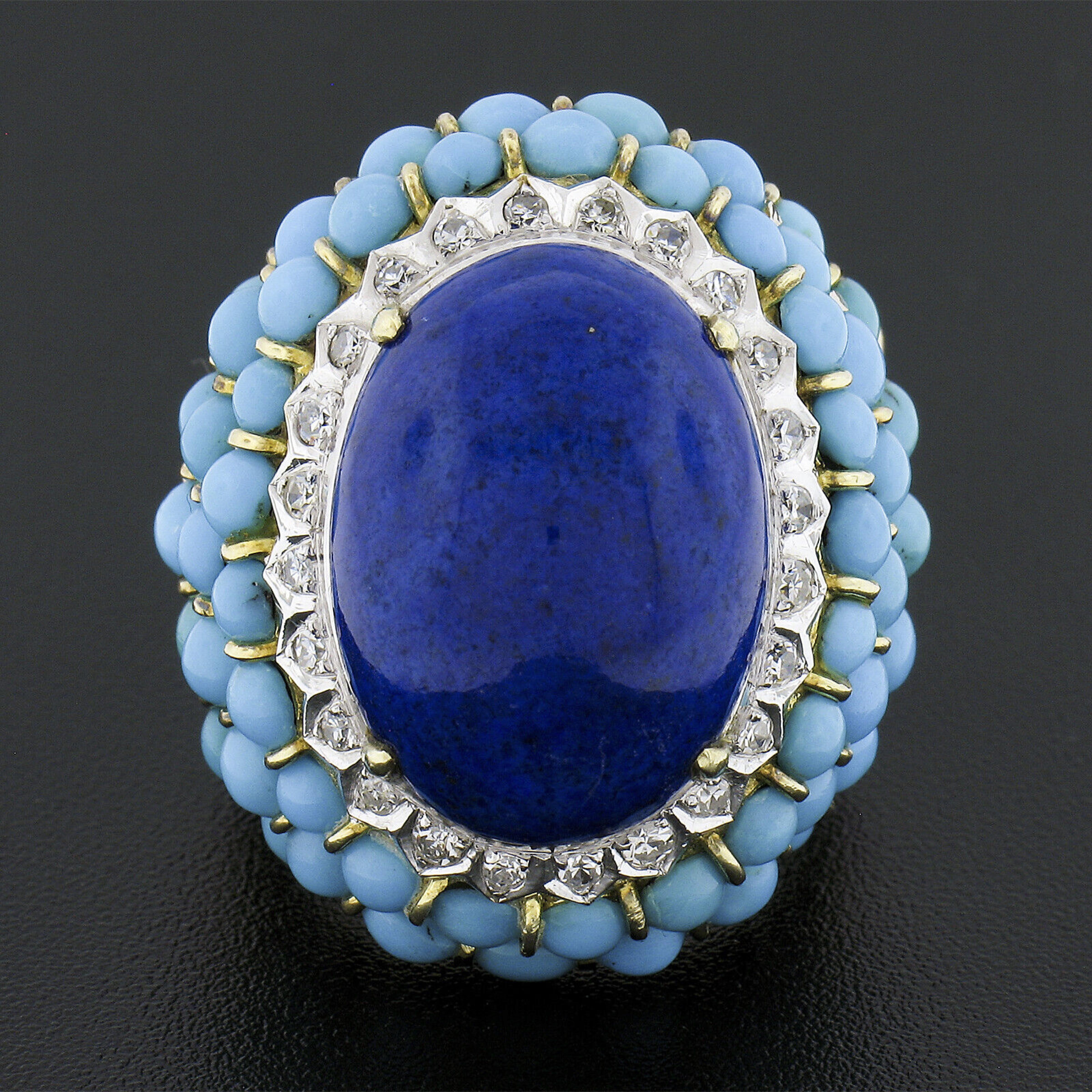 Here we have an absolutely magnificent and uniquely designed vintage cocktail ring that is crafted from solid 14k yellow and white gold. It features a gorgeous, high quality, natural lapis stone neatly prong set at its center and further accented