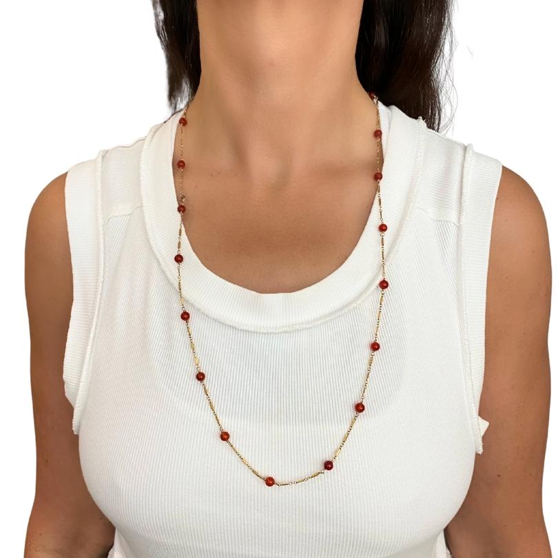 This elegant vintage necklace showcases vibrant, carnelian beads spaced along a finely crafted 14k gold chain. Measuring 29 inches in length, the piece features round polished carnelian gemstones—each a warm, translucent red-orange—securely linked