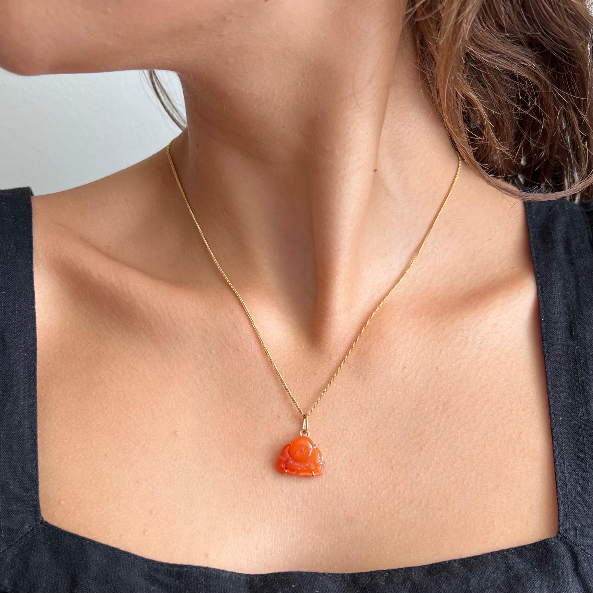 A vintage buddha charm pendant made of carnelian and set in a 14 karat gold frame. The color of this lovely carnelian buddha has a beautiful orangish hue. 

Collect your own charms as wearable memories, it has a symbolic and often a sentimental