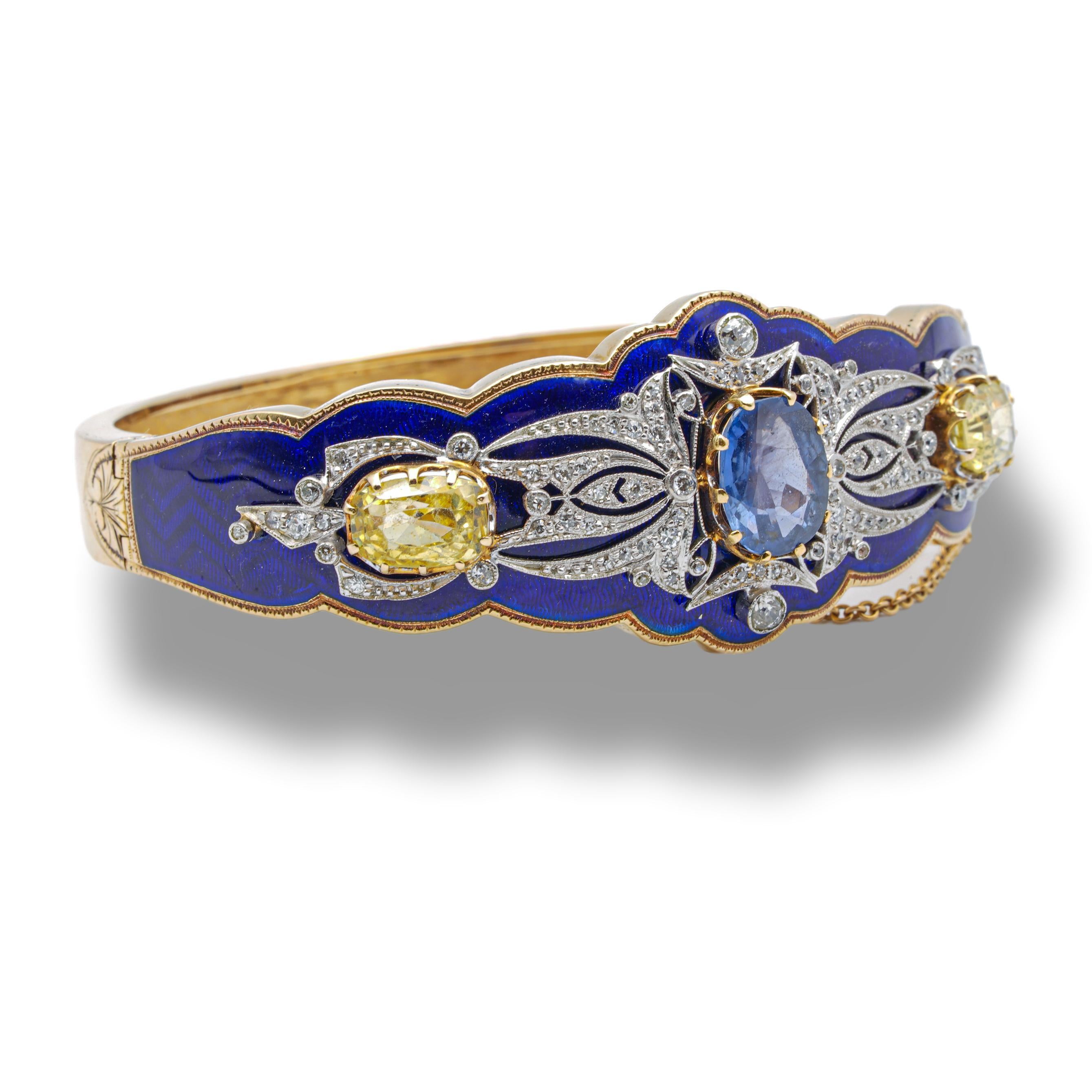 Vintage bangle bracelet finely crafted in 14 Karat Gold featuring an exquisite Royal blue enamel finish and a mix of blue and yellow sapphires. One center oval blue sapphire weighs 3.48 cts and is certified by AGL ( American Gemological