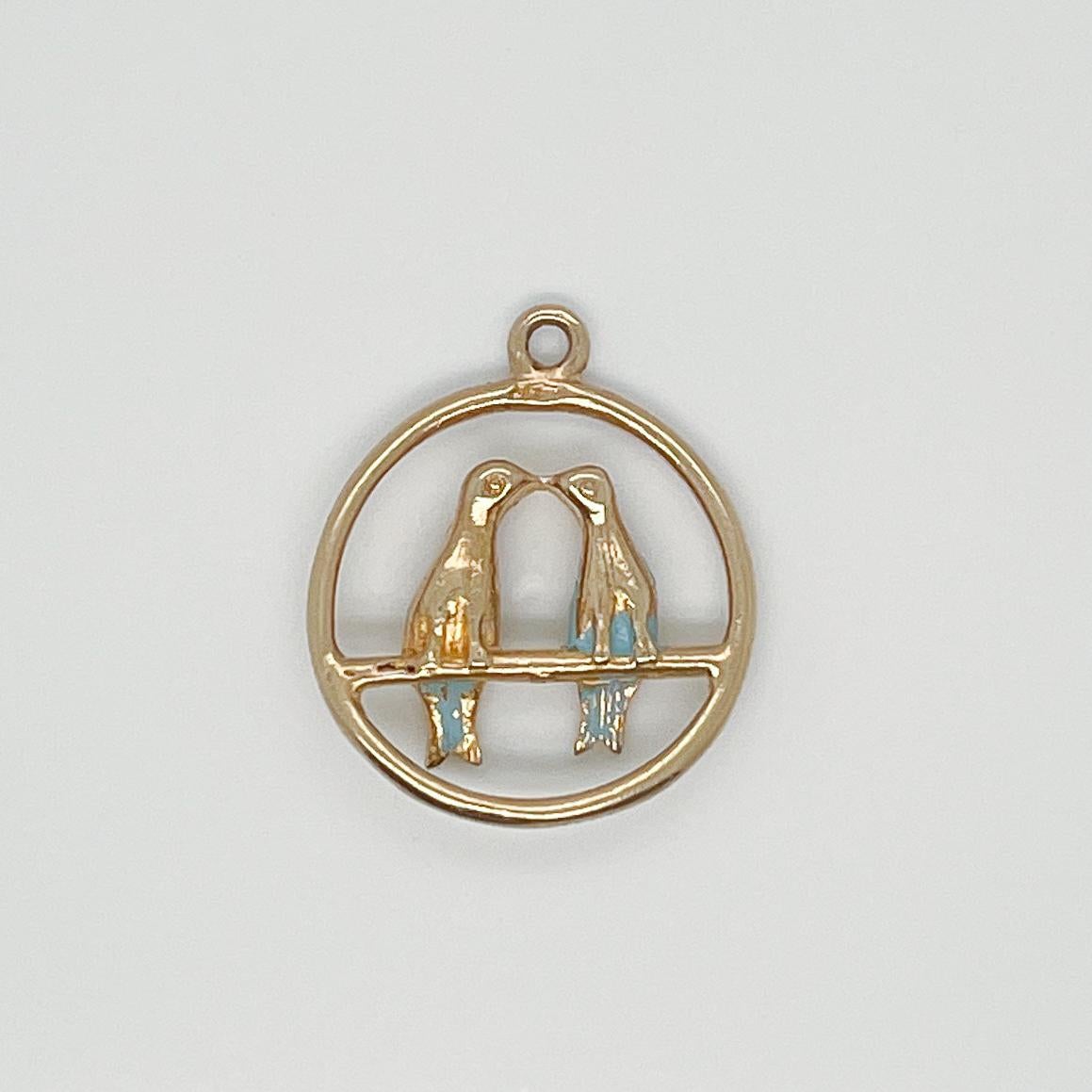A vintage 14 karat gold charm for a charm bracelet. 

In the form of two lovebirds kissing in a ring.  

A rare and terrific charm!

Date:
Mid-20th Century
 
Overall Condition:
It is in overall good, as-pictured, used estate condition with some very